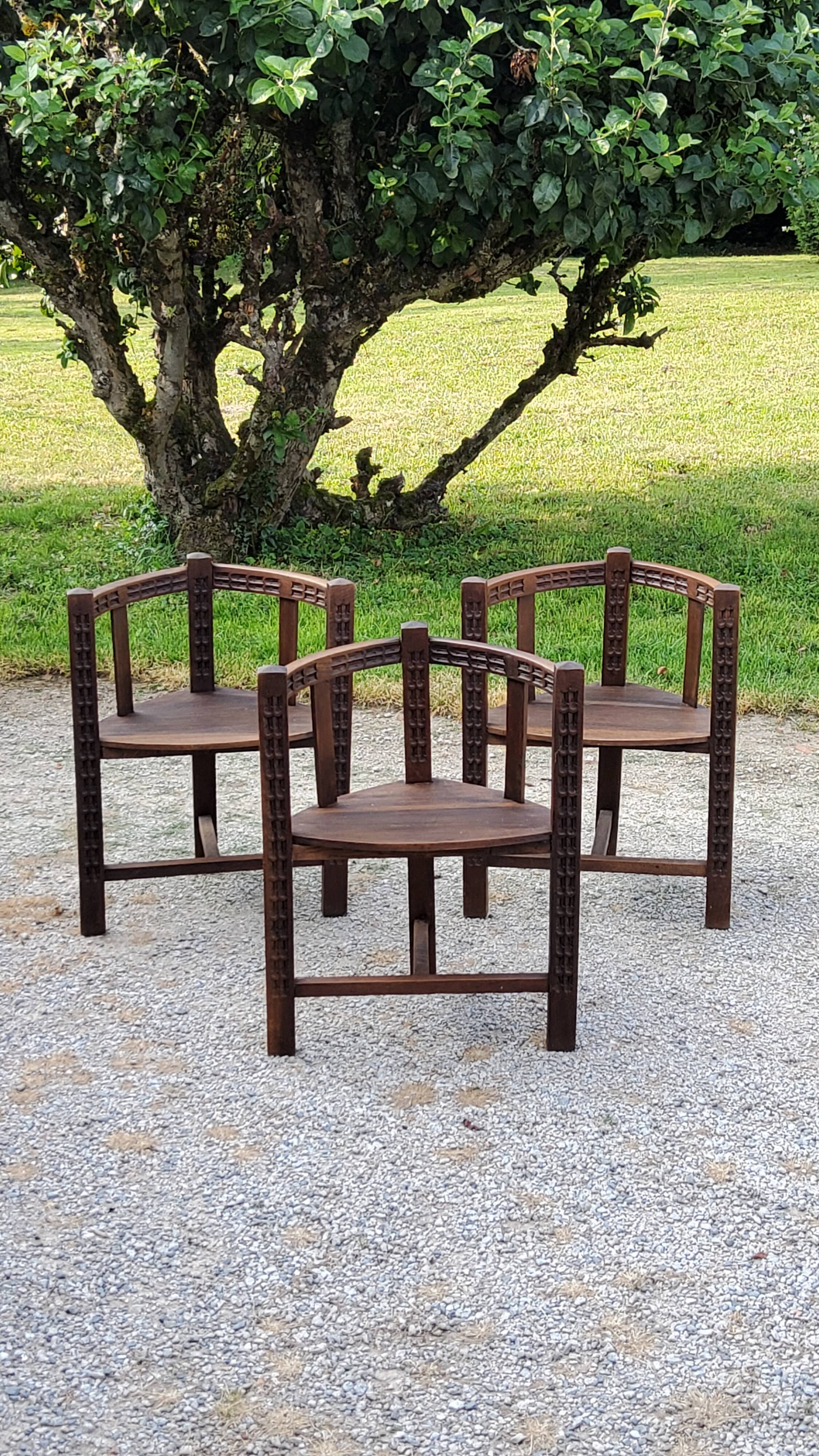 Set of three brutalist tripod armchairs in carved solid oak