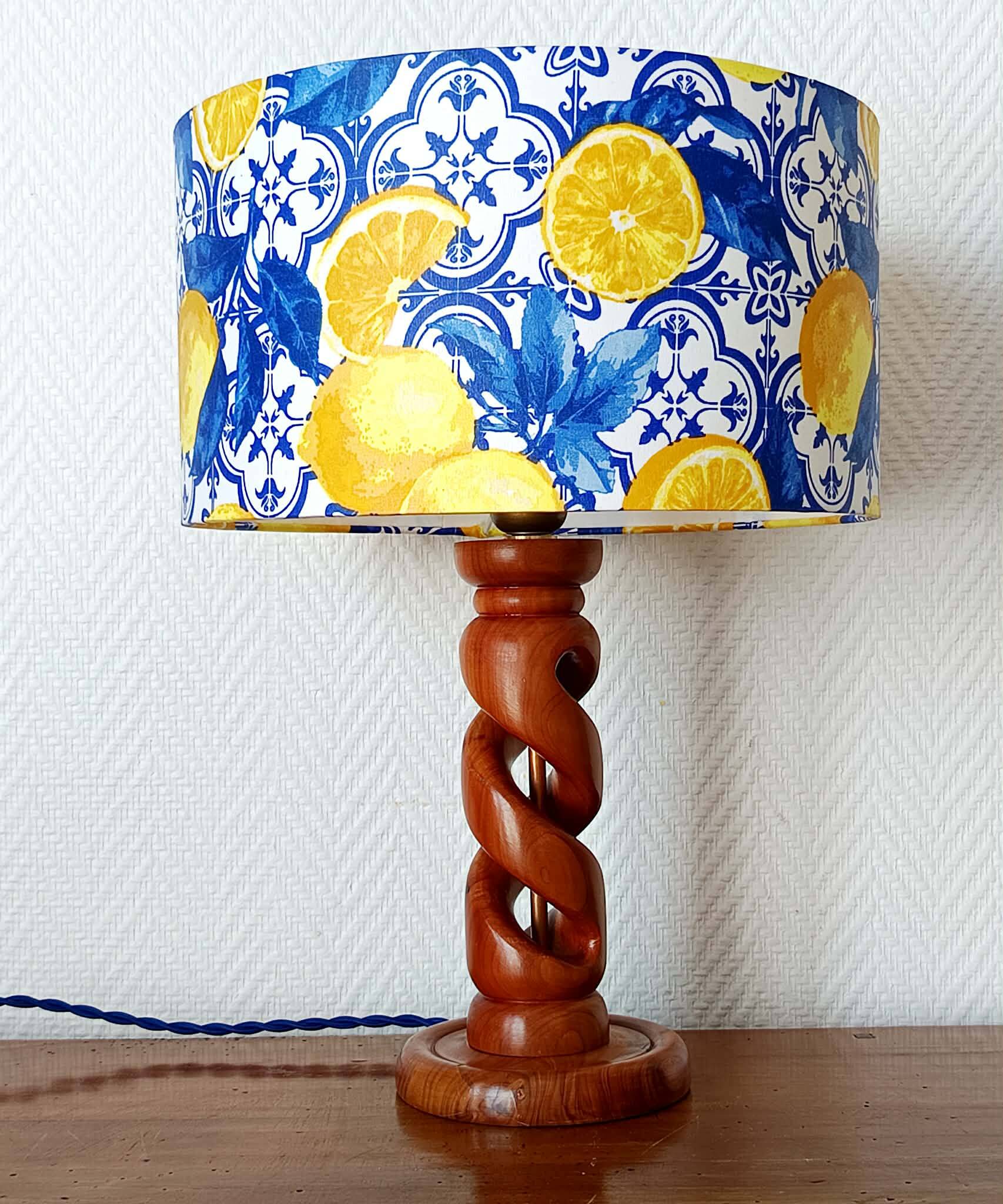Turned wooden lamp with a lampshade featuring lemon tiles.