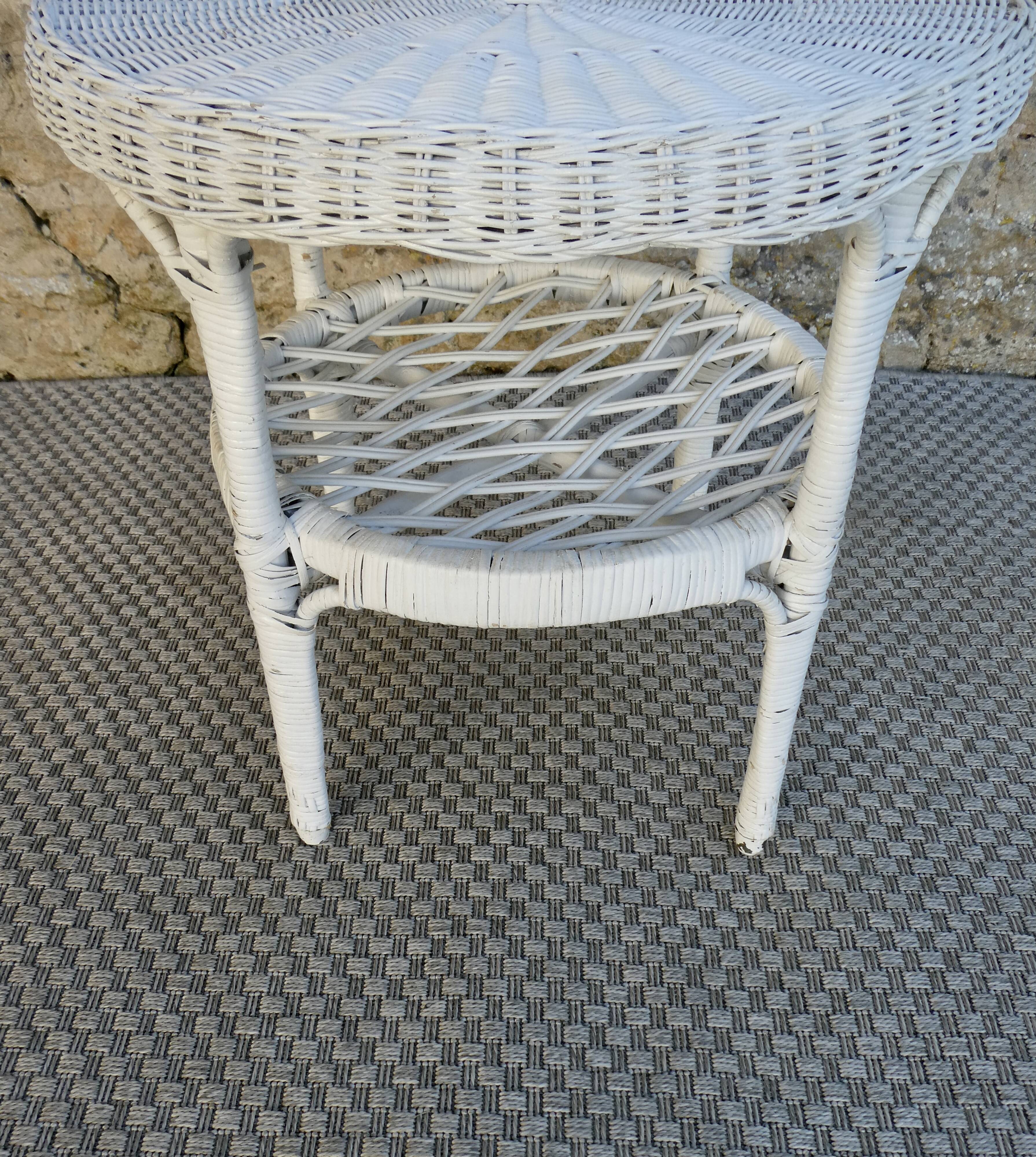 Round white rattan side table with storage underneath, circa 1970.