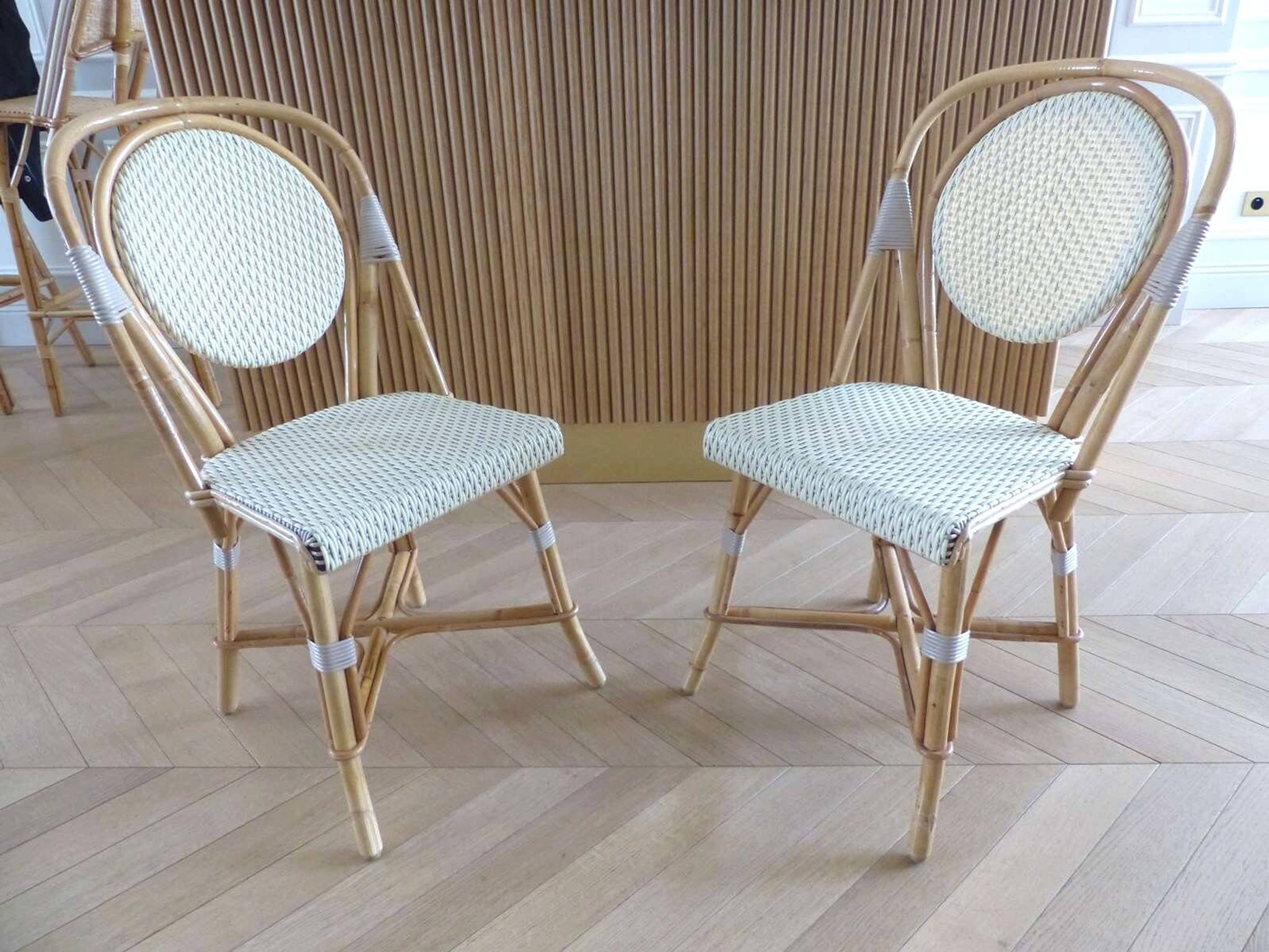 Pair of Parisian bistro chairs from Maison Louis Drucker in light Manila rattan.