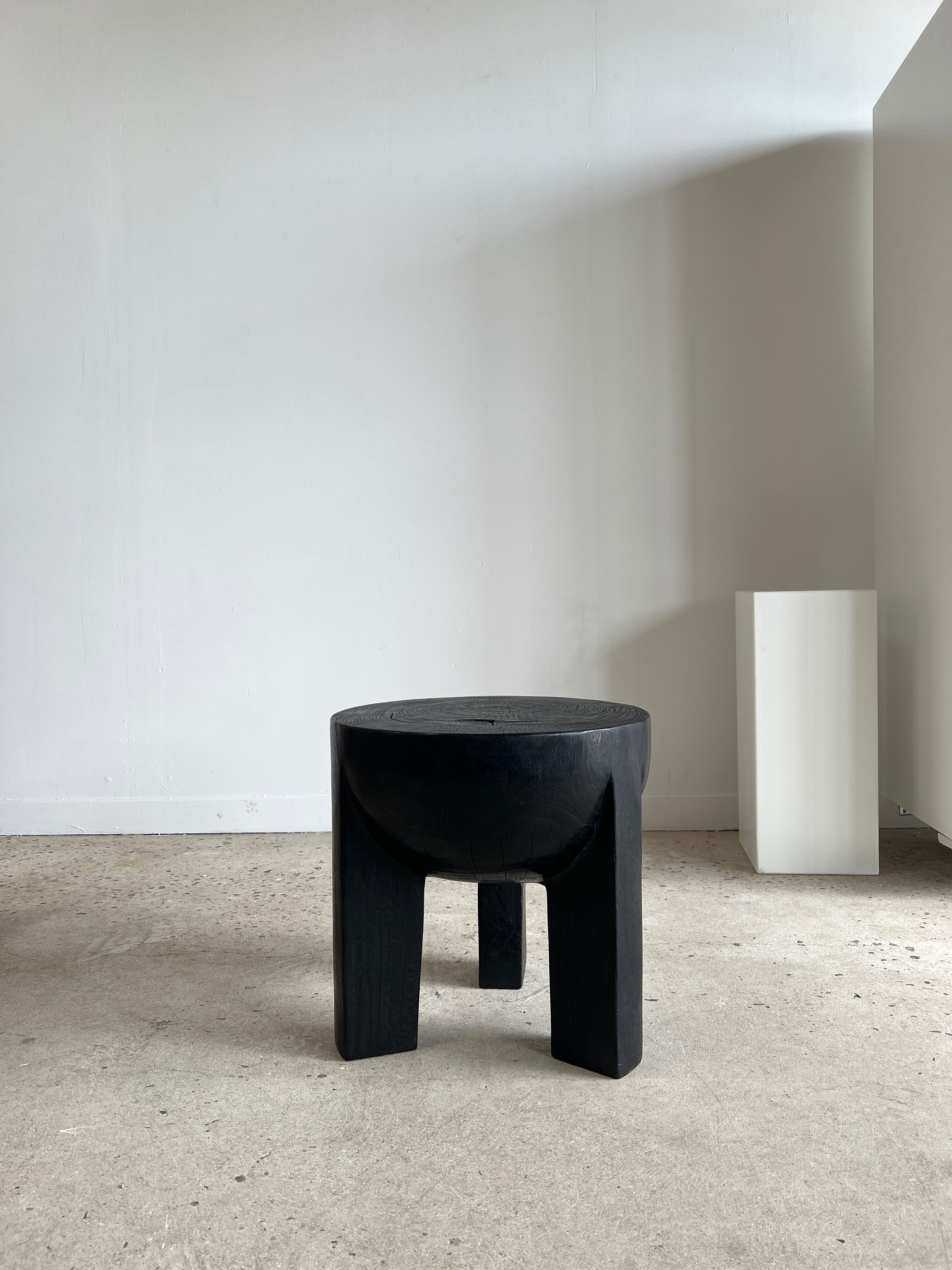 Black mango wood tripod side table with a semi-spherical top, height: 45 cm, diameter: 44 cm.