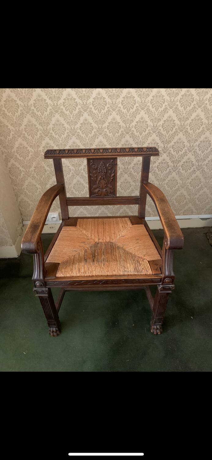 Antique armchair in carved wood with a straw seat.