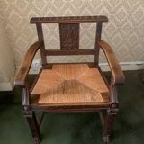 Antique armchair in carved wood with a straw seat.