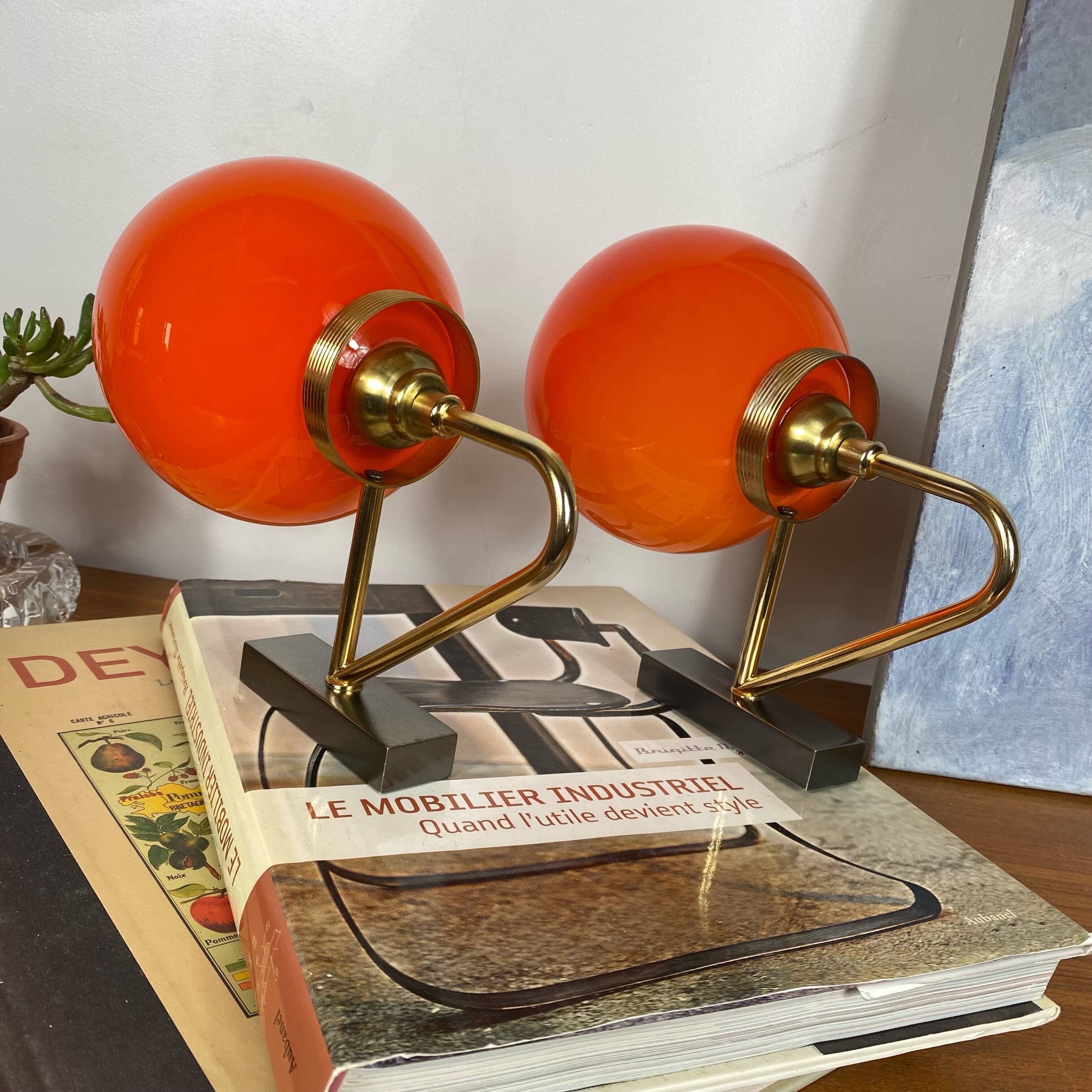Pair of wall sconces with orange opaline globes and gold metal.