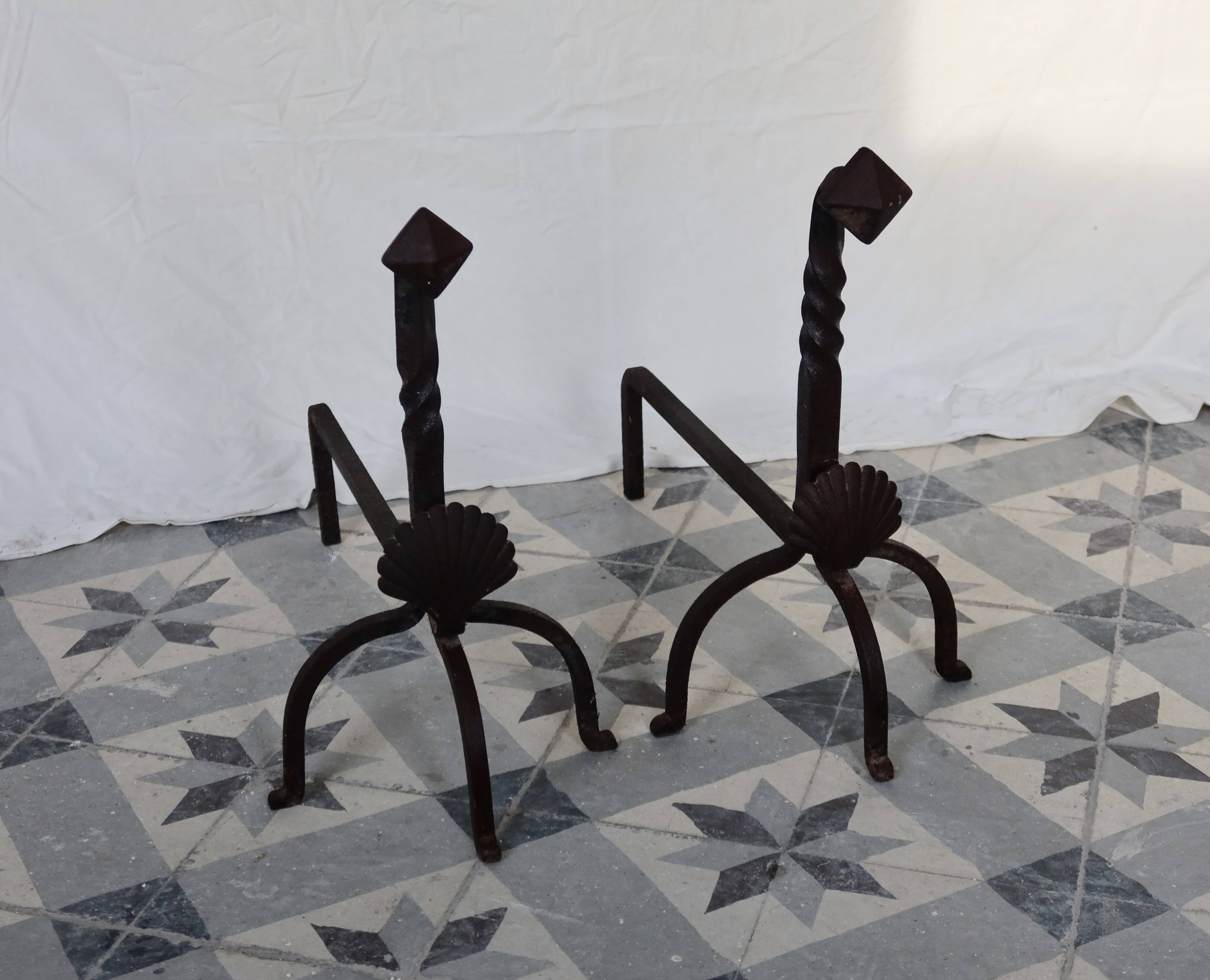 Vintage metal and cast iron fire dogs with shell motif.