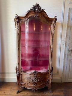 Large wooden display cabinet in Louis XV/rococo style with a strongly curved front.