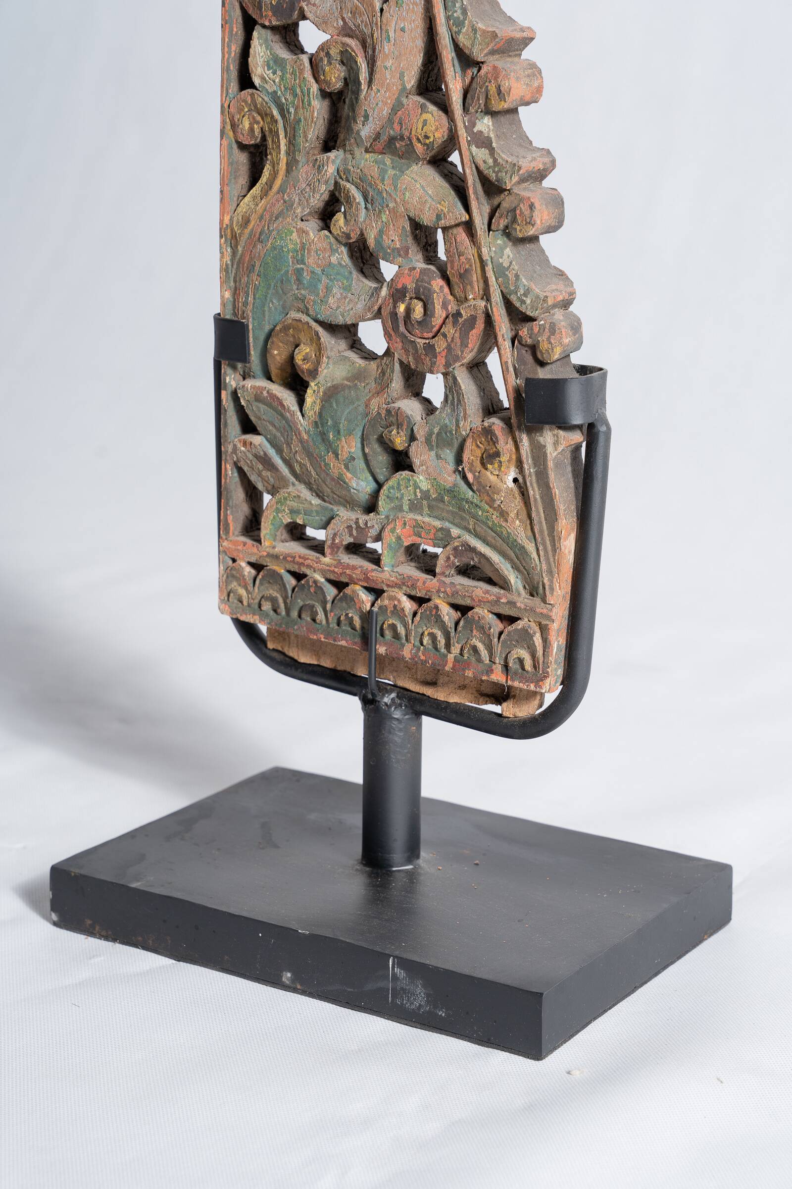 Indonesian construction element in carved wood with intertwined plant motifs mounted on a base (fri