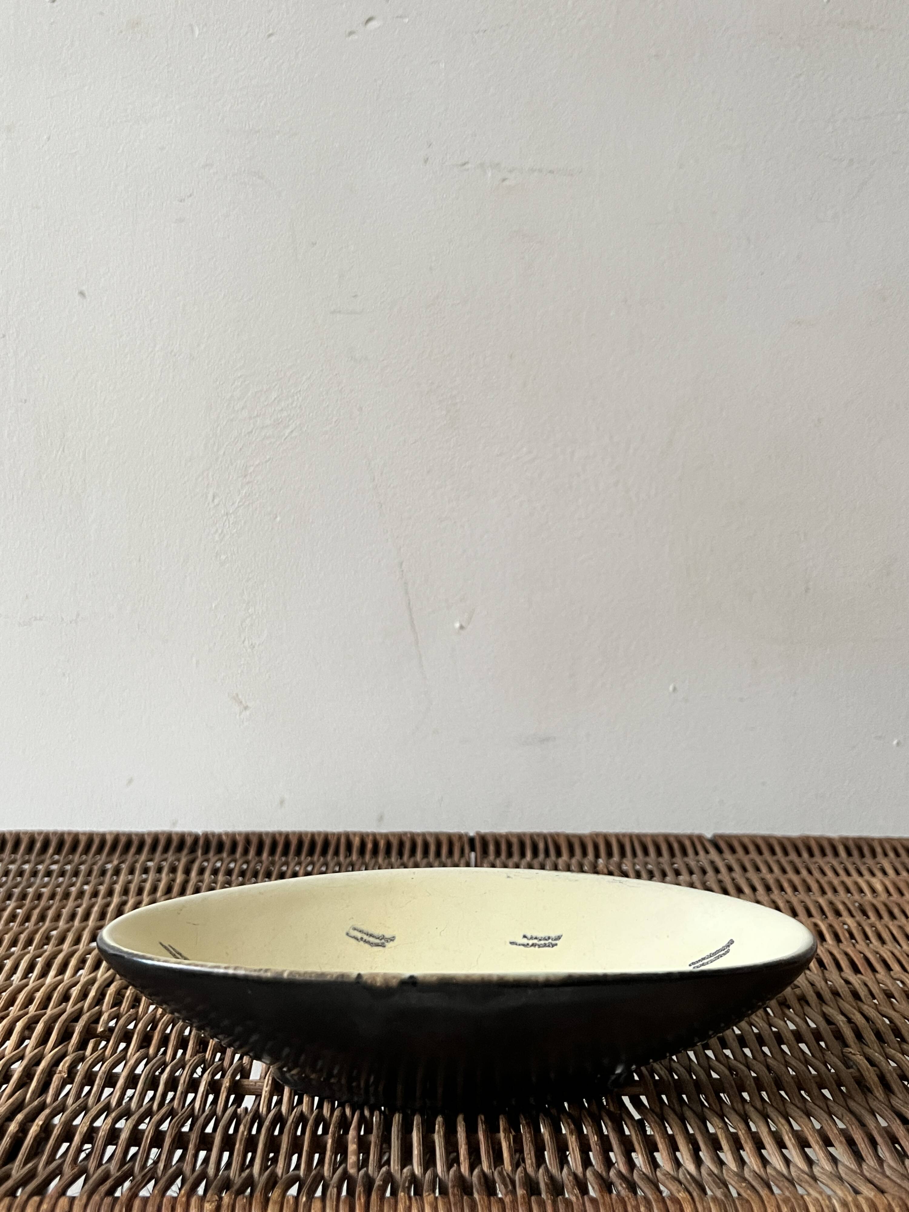 Pale yellow and black ceramic bowl / empty pocket signed by the artist