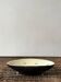 Pale yellow and black ceramic bowl / empty pocket signed by the artist