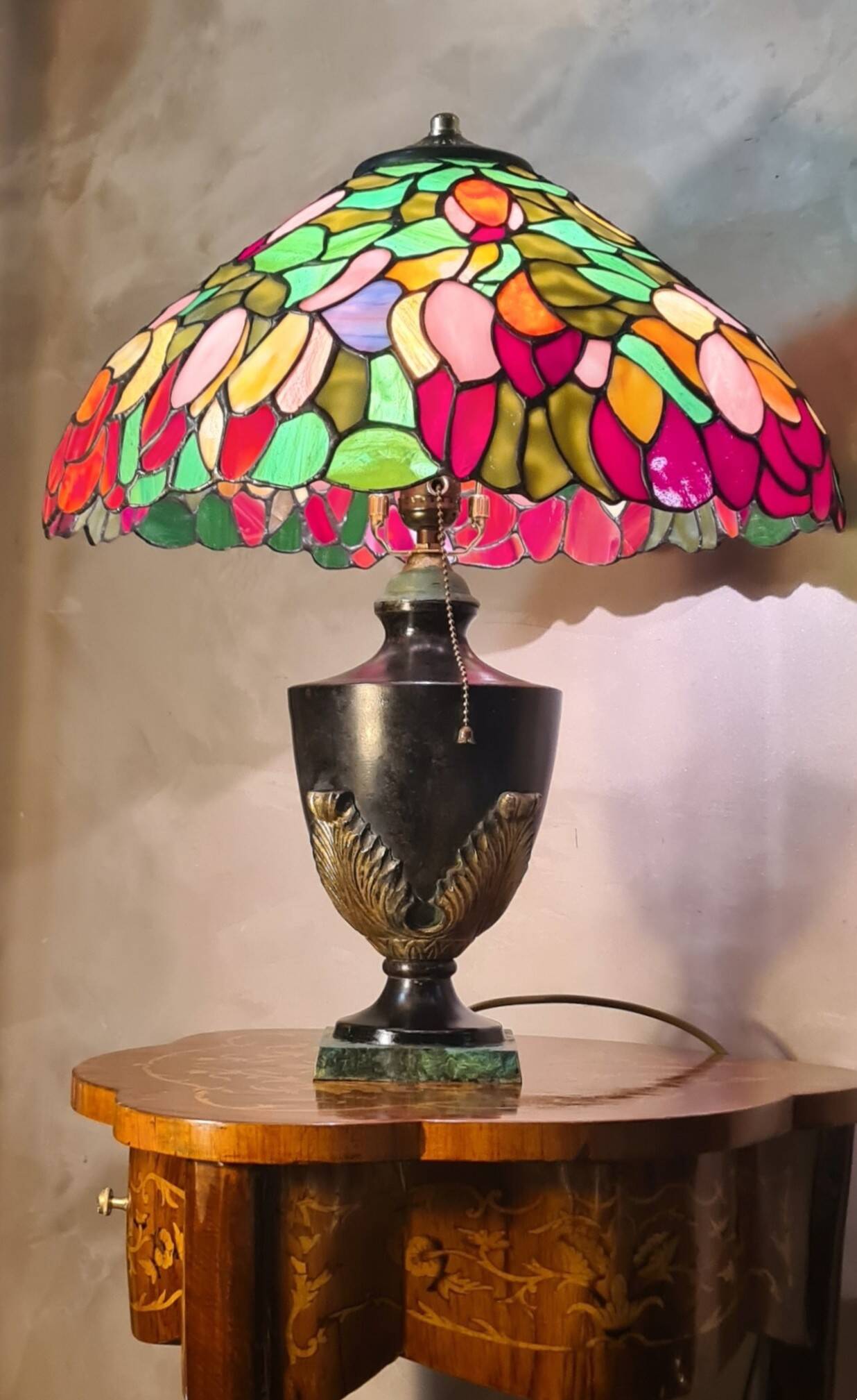 antique patinated cast iron lamp with a glass paste lampshade, showing signs of wear.