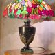 antique patinated cast iron lamp with a glass paste lampshade, showing signs of wear.