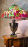 antique patinated cast iron lamp with a glass paste lampshade, showing signs of wear.