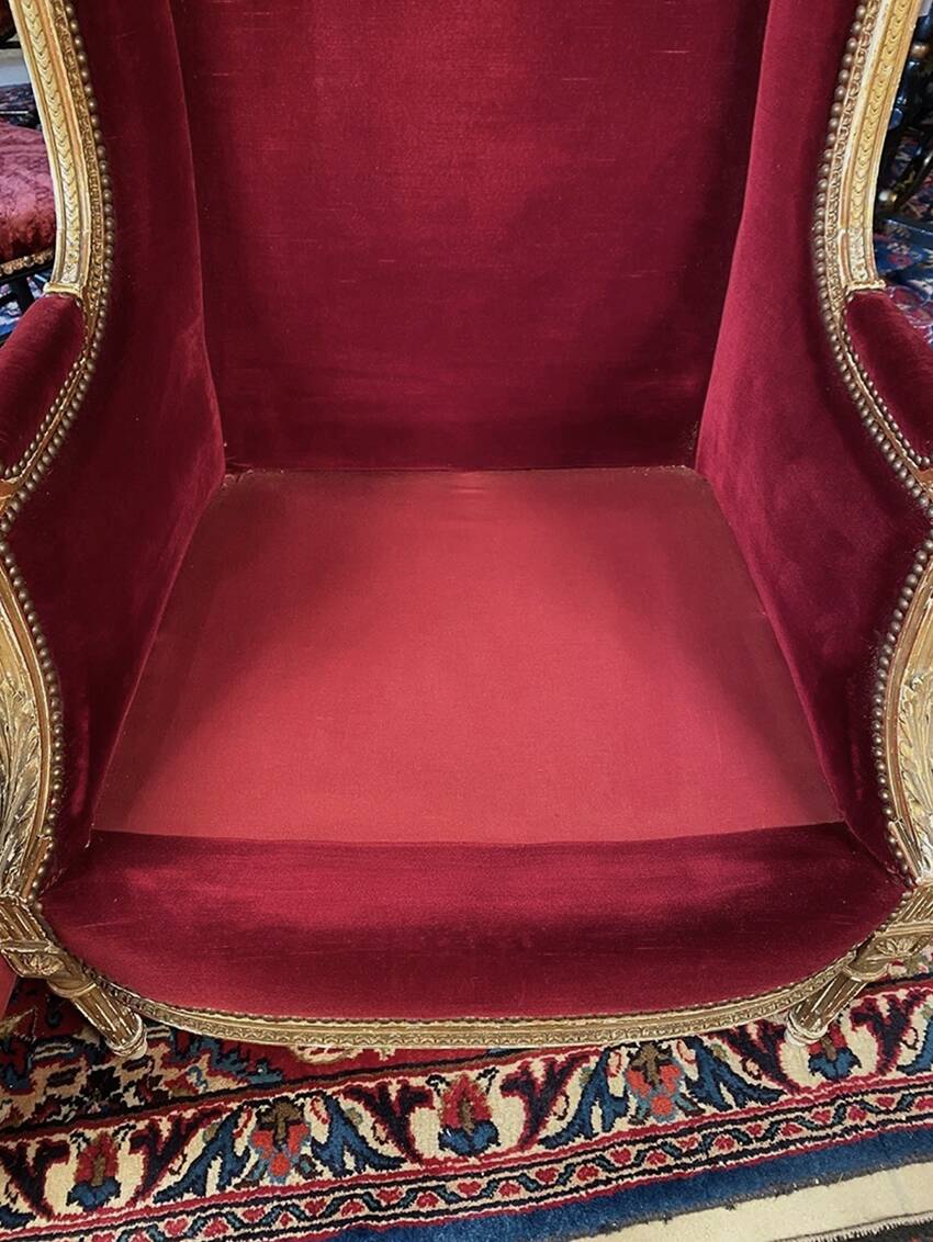 Golden wooden bergère in Louis XVI style upholstered in Bordeaux velvet.