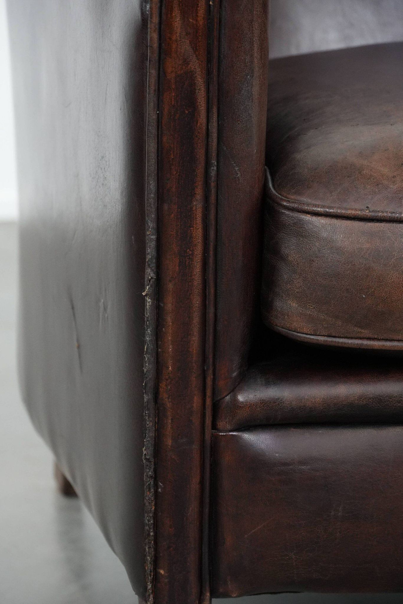 Stylish and sturdy dark brown club armchair made of sheepskin leather