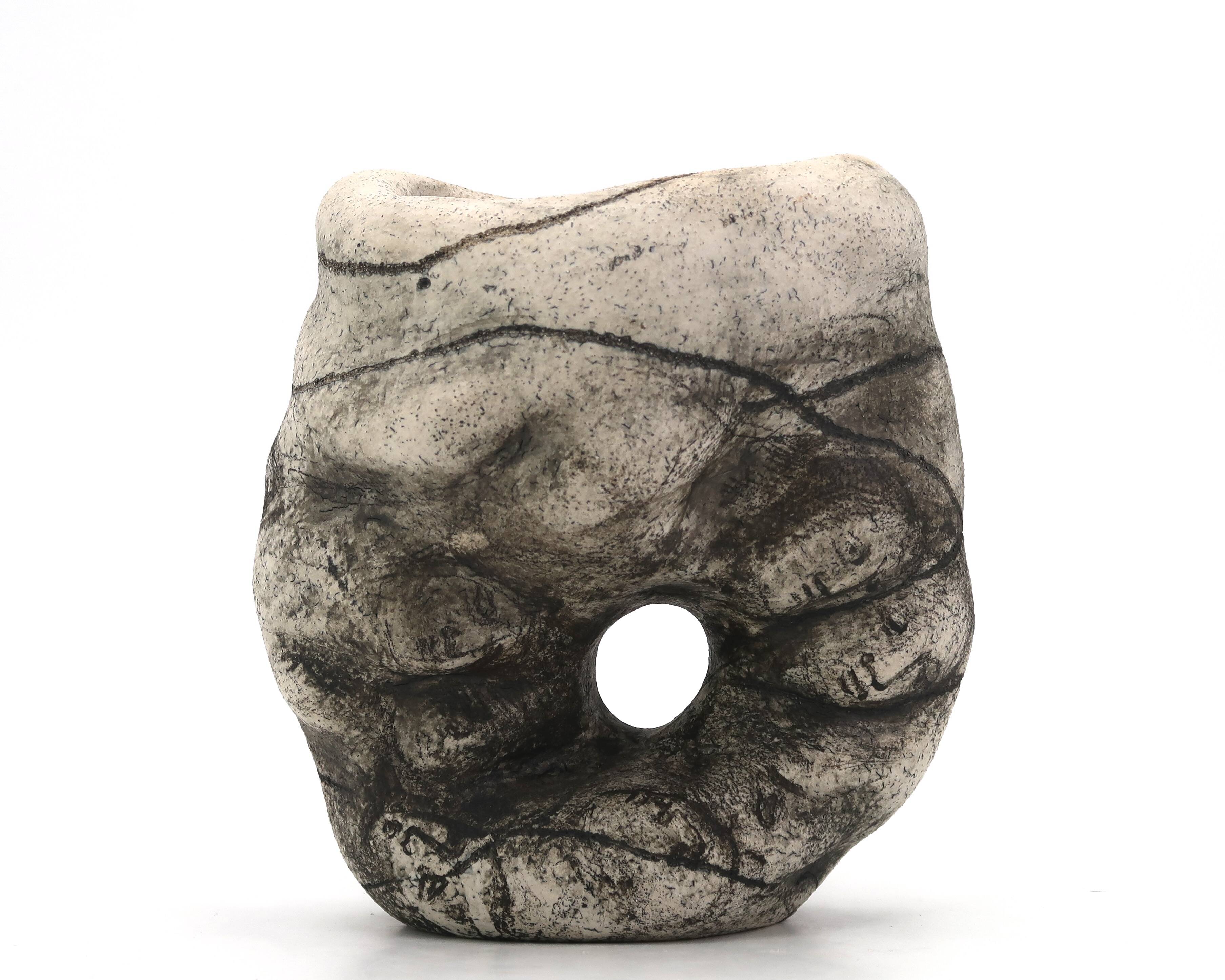 Ceramic vase sculpture decorated with faces and featuring a hole, 1980s.