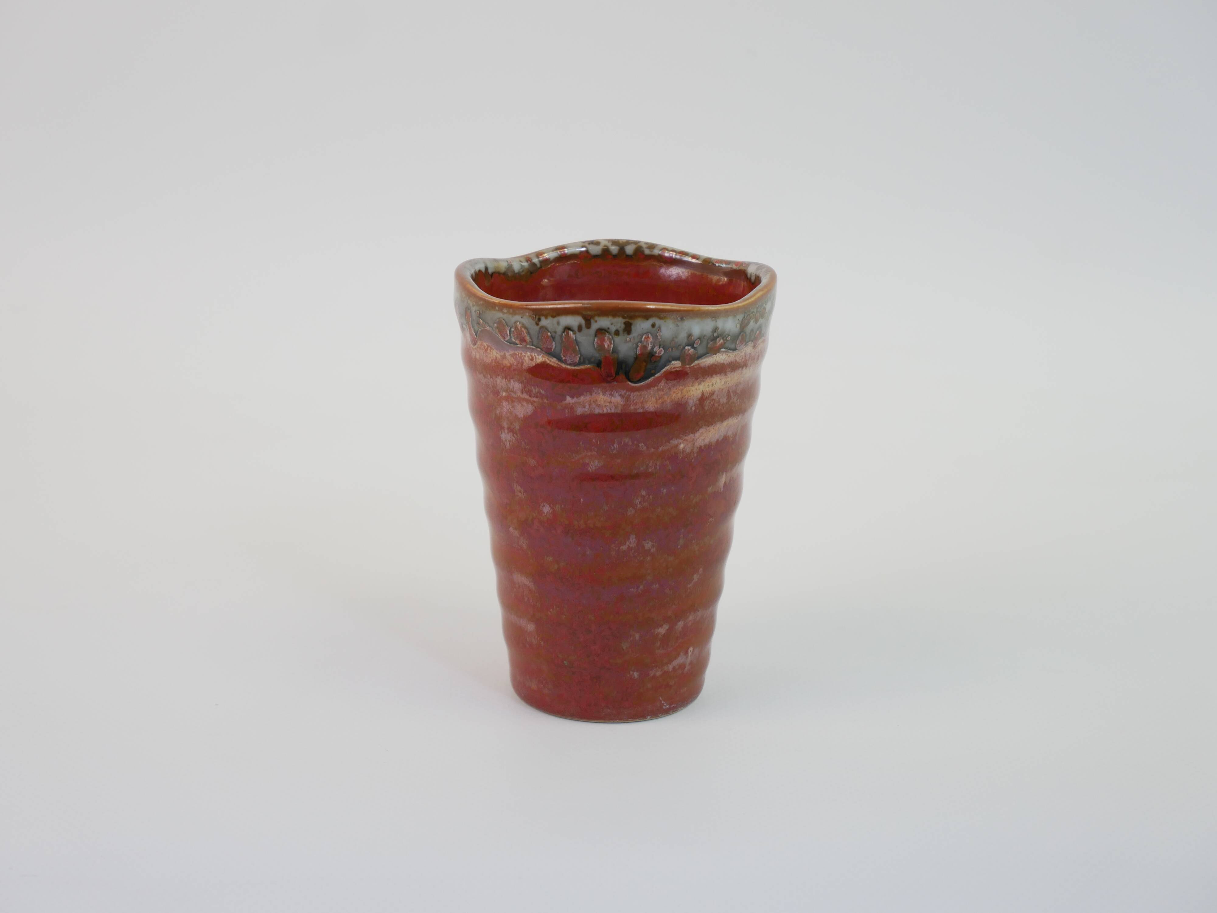 Small orange glazed ceramic cup