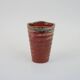 Small orange glazed ceramic cup