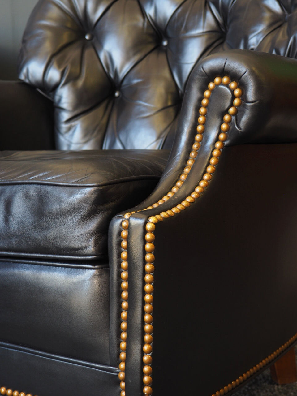 Chesterfield style leather armchair & footstool by Hancock & Moore