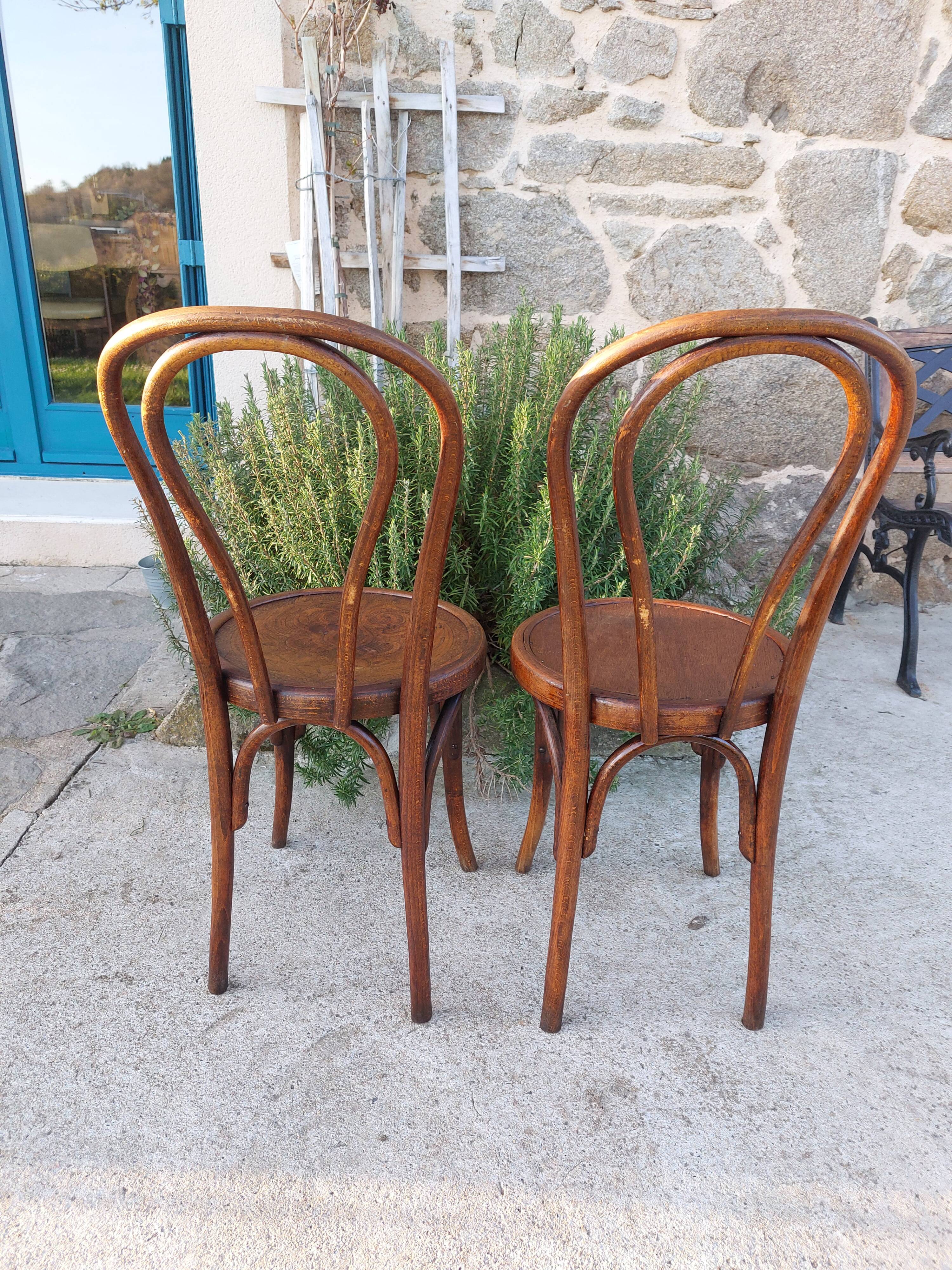 pair of round wooden chairs with a pattern on the seat