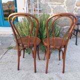pair of round wooden chairs with a pattern on the seat