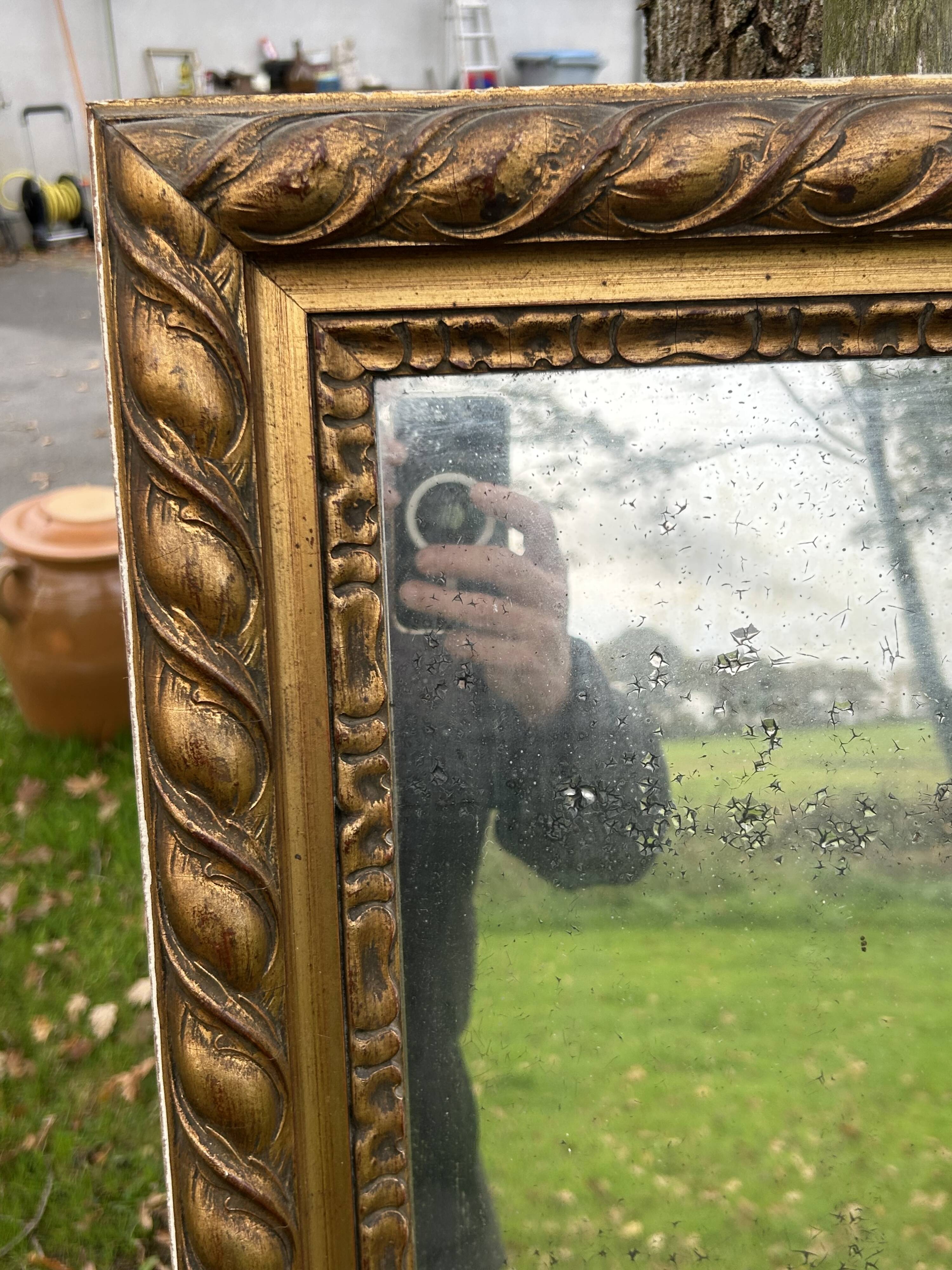 Large antique gilded mirror, wood and stucco gadroons, partially de-mercury