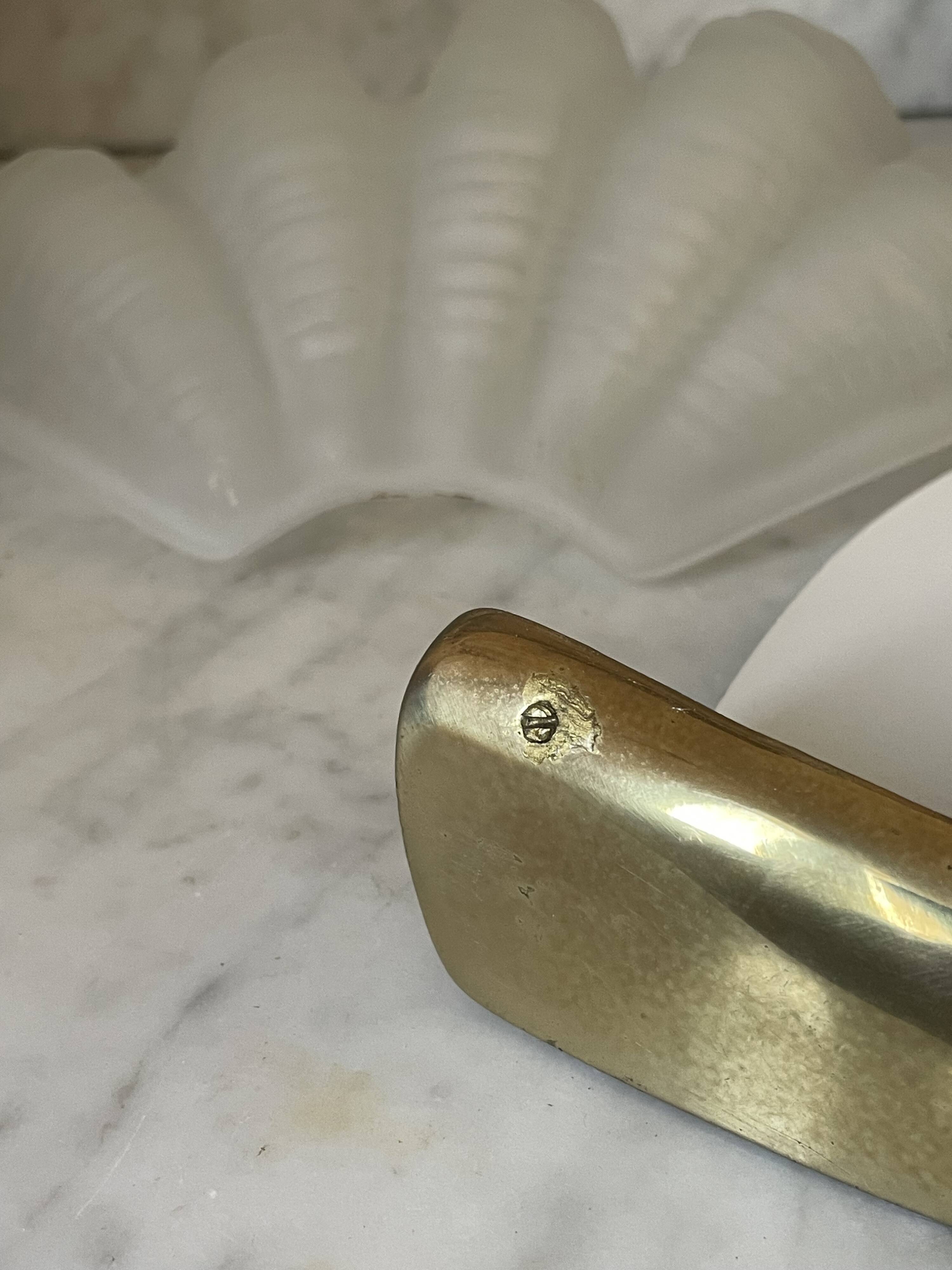 Shell-shaped wall light in Art Deco style with frosted glass and gilded bronze.