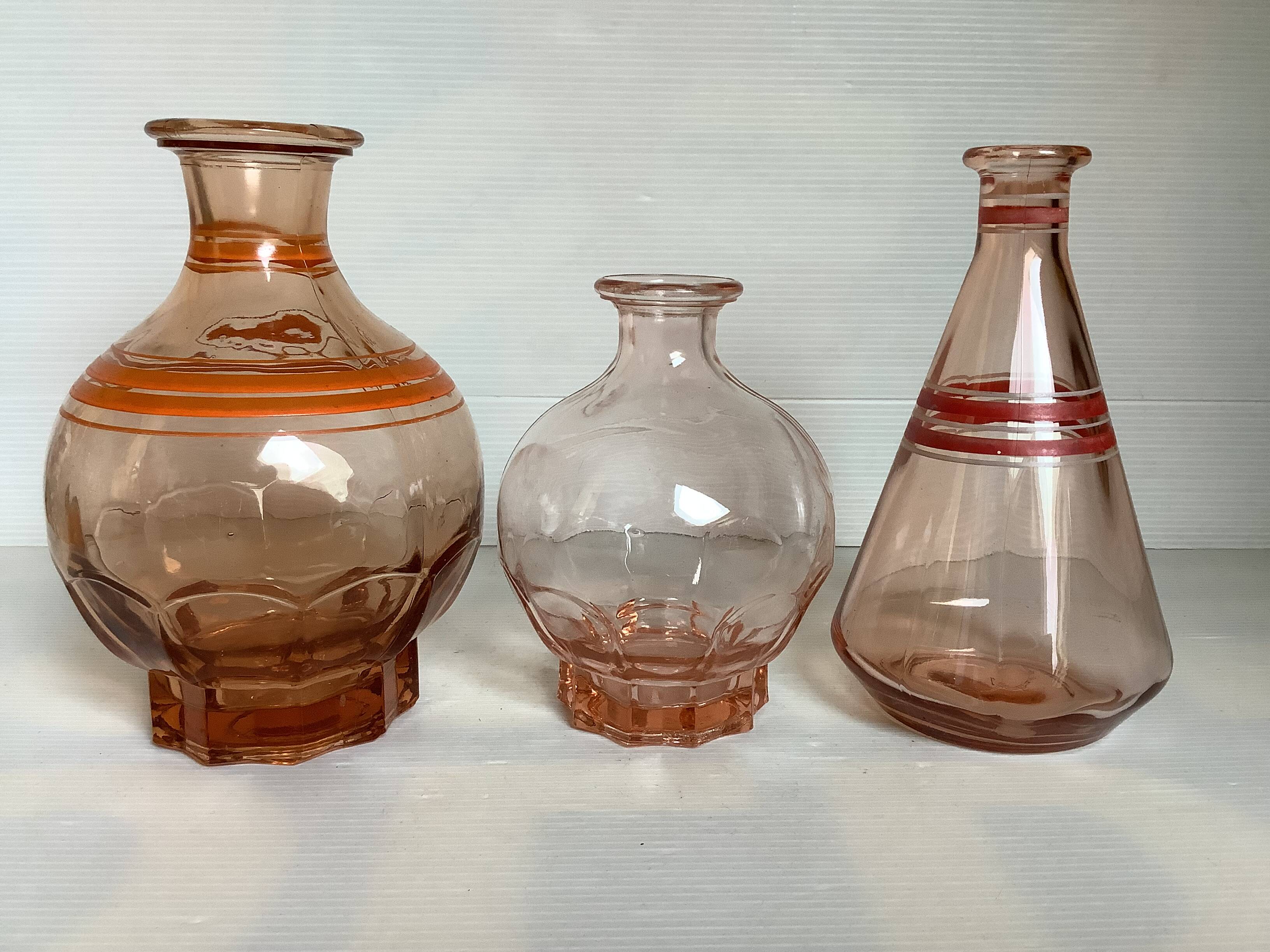 Trio of pink bottle decanters