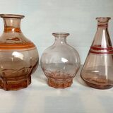 Trio of pink bottle decanters