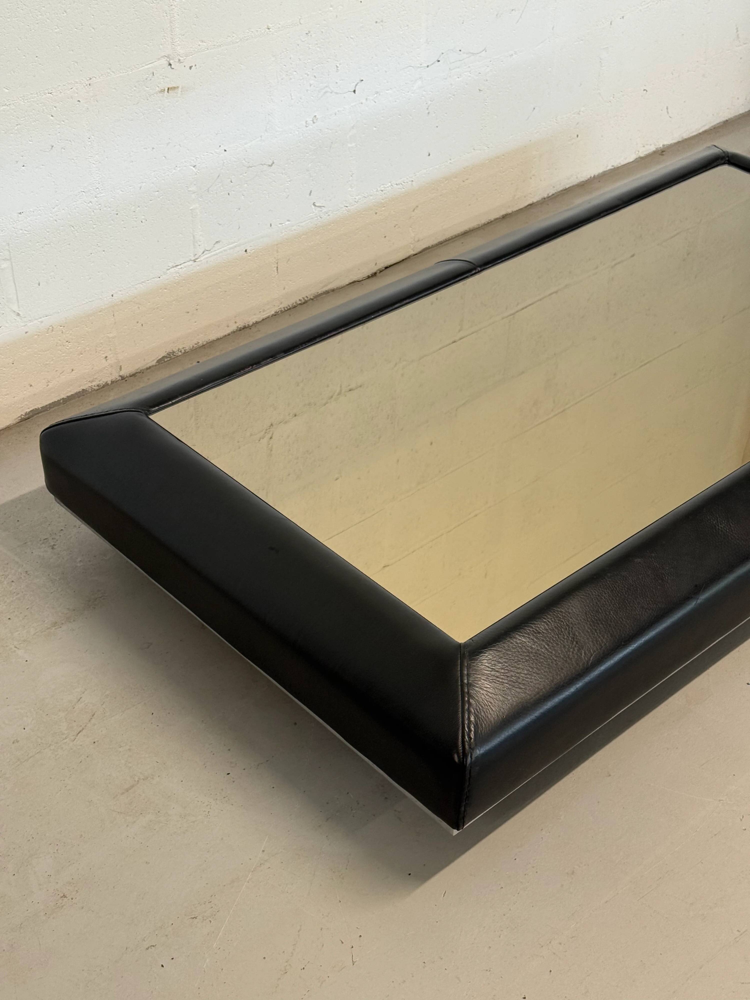 Vintage coffee table covered in leather, smoked mirror top and chrome legs.