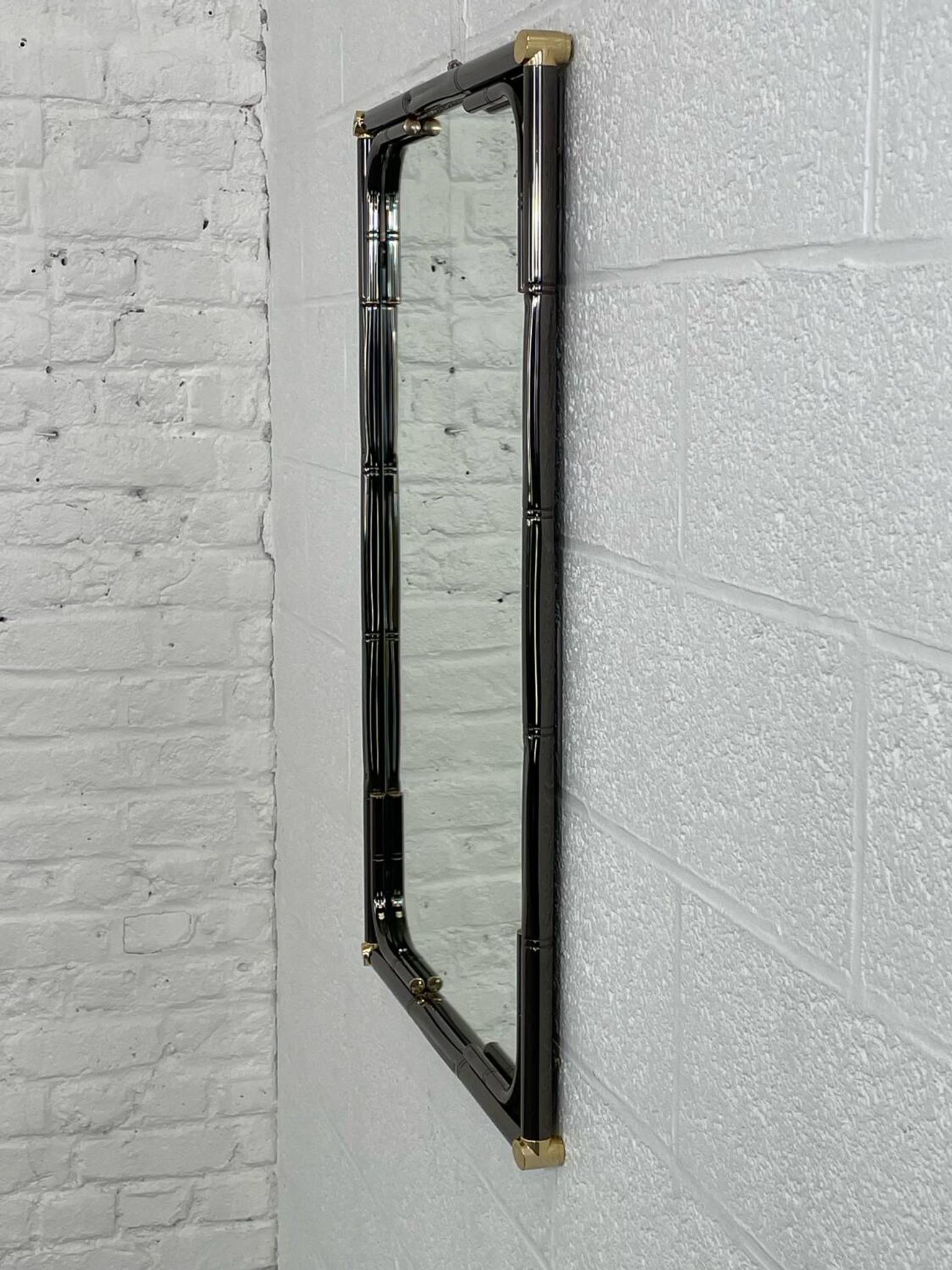 Mirror in black metal and brass with gunmetal finish