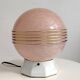Art Deco lamp with a speckled pink glass globe and a white ceramic base.