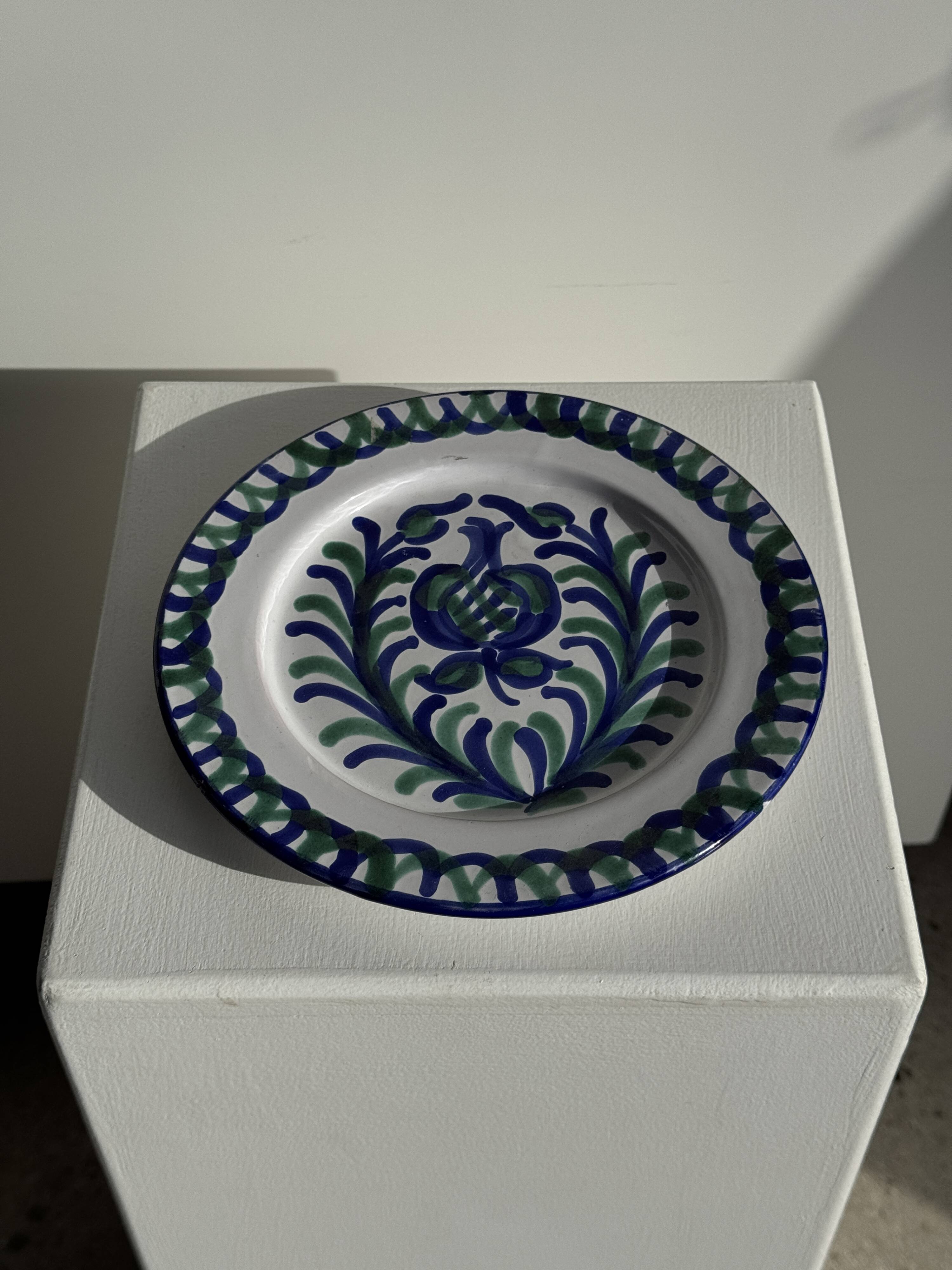 Artesania Alvarez Spanish plate in terracotta with blue plant motif.