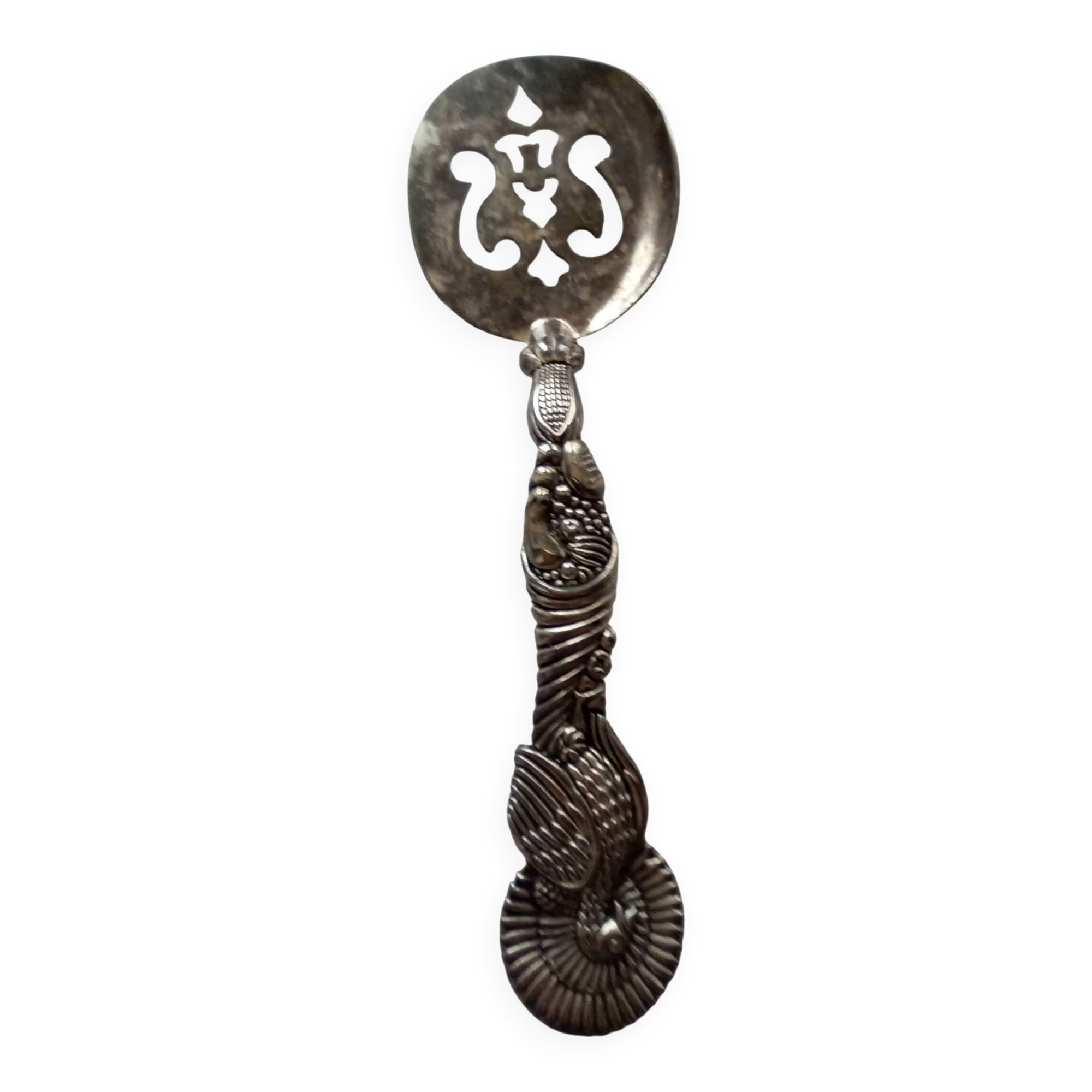 Vintage serving spoon with a carved relief handle.