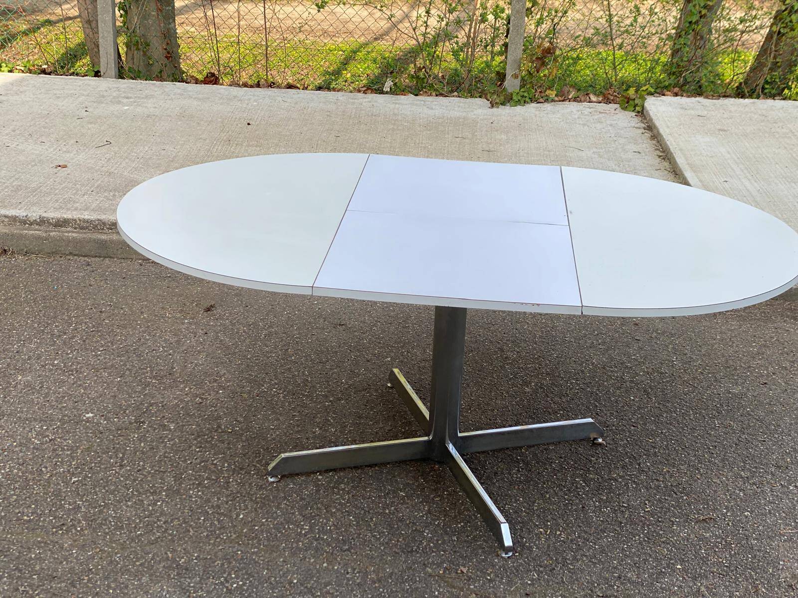 White dining table with a central pedestal, extendable, from the 1970s.
