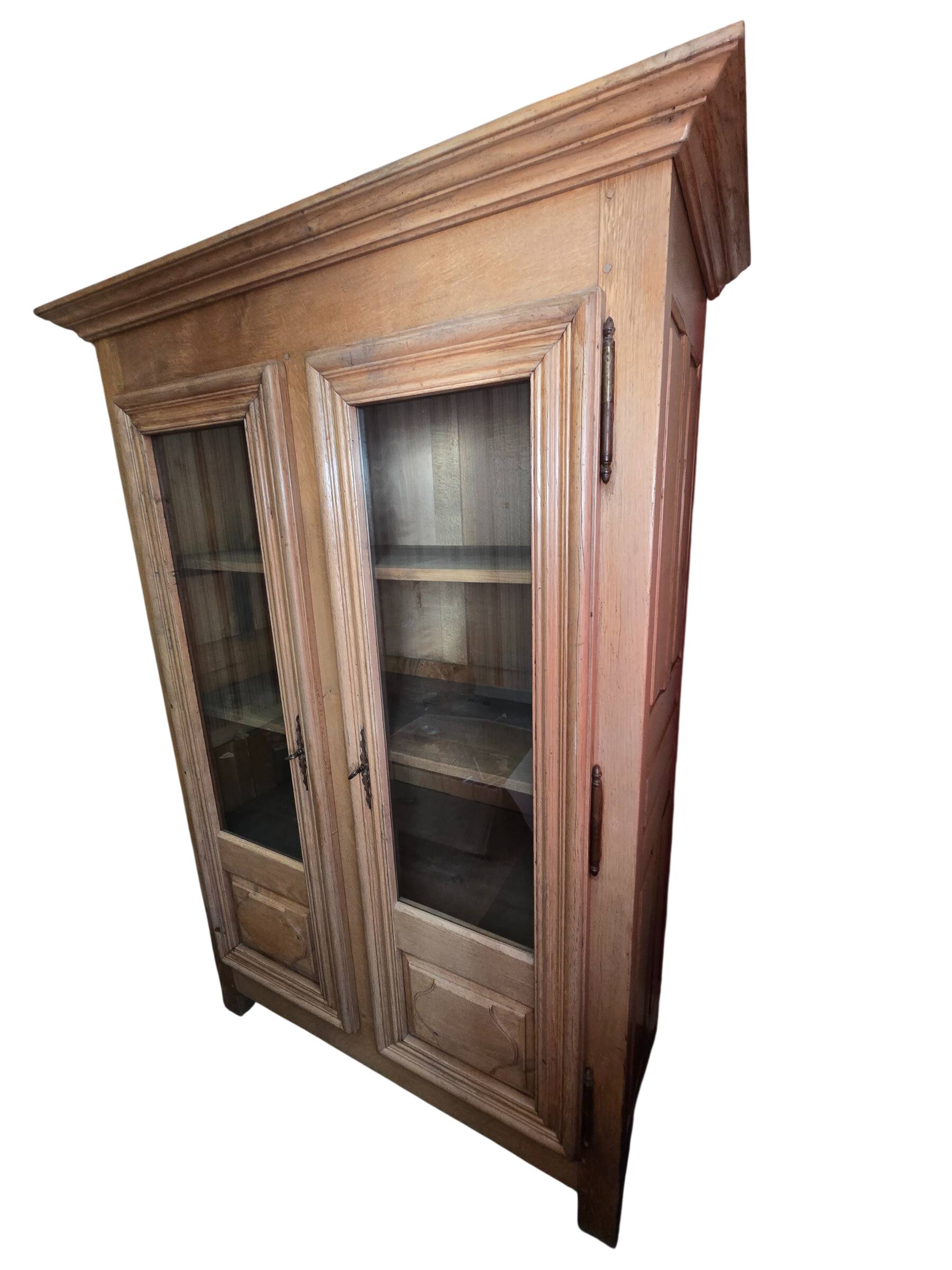 Antique display cabinet in solid oak with two glass doors.