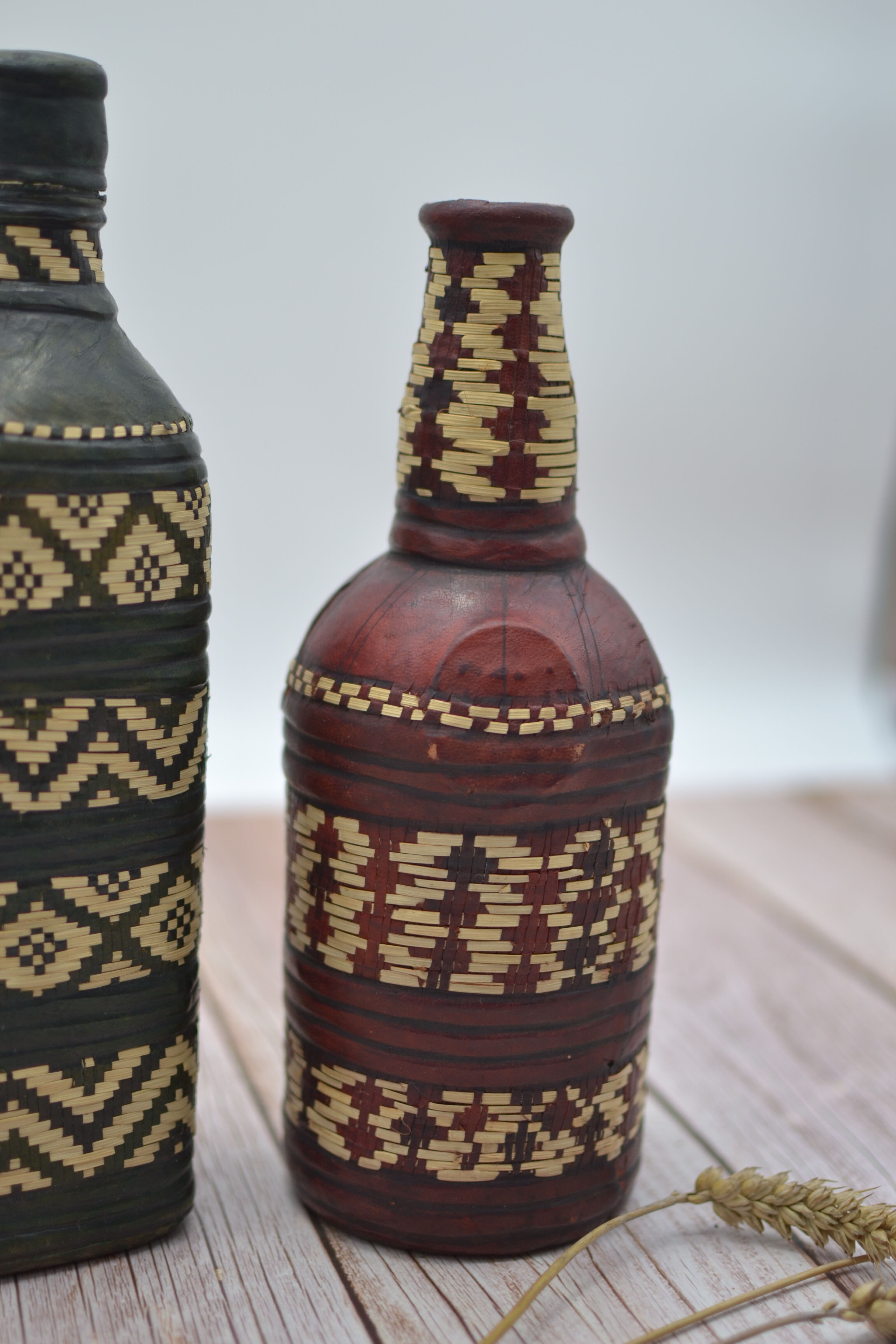 Set of 2 decorative vintage bottles covered with leather & wicker