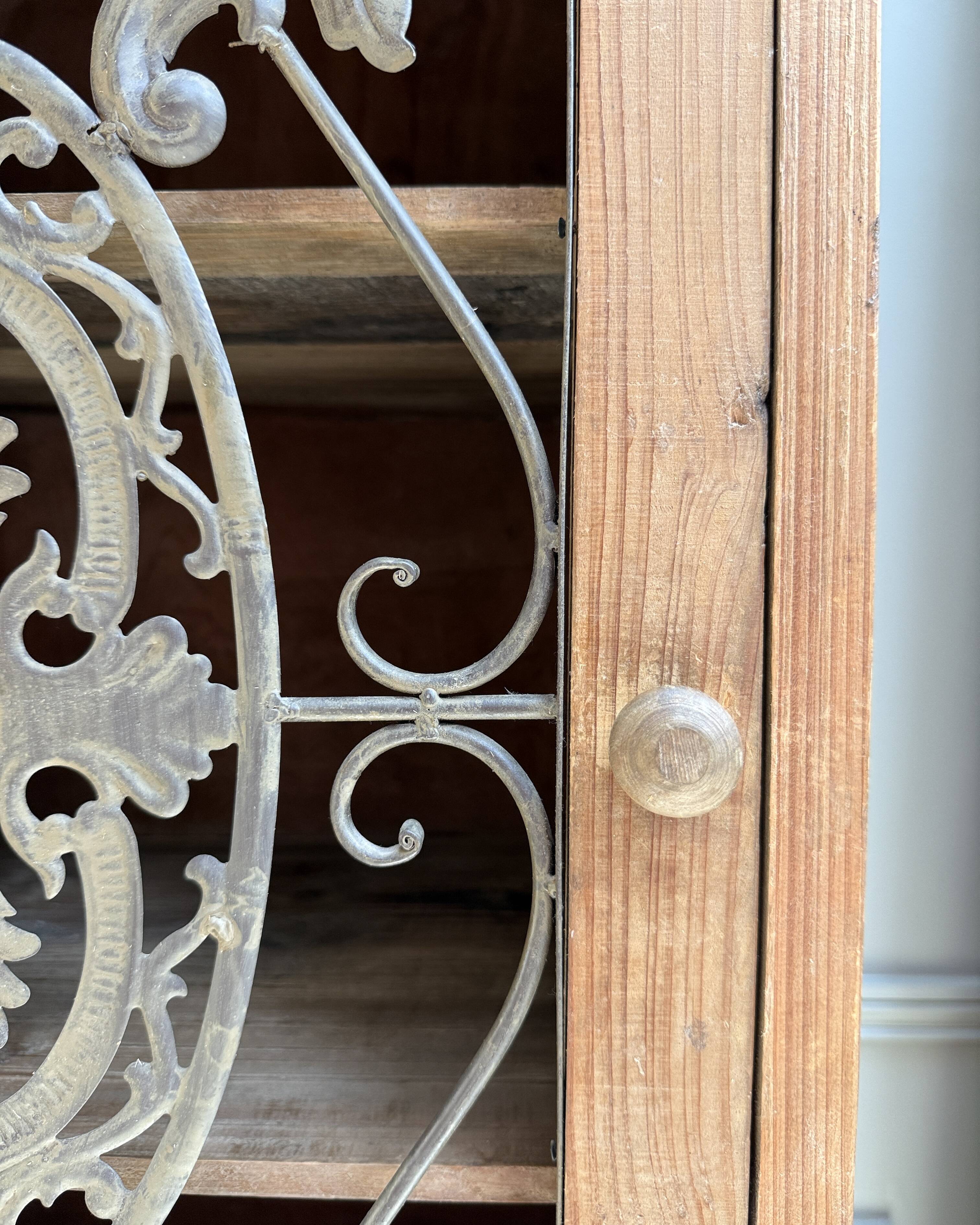 Column storage unit with a sculpted metal door.