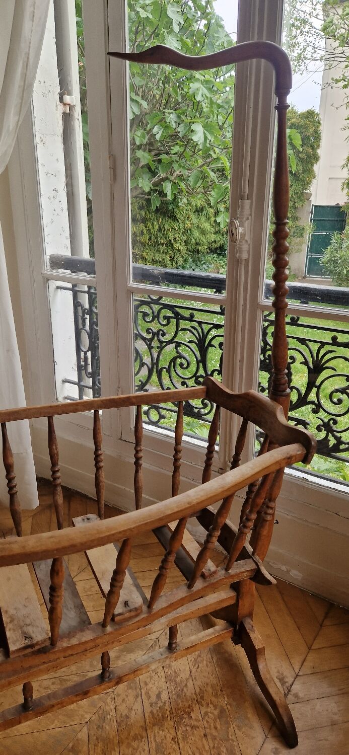 Wooden cradle in walnut with a sign collar at the top.