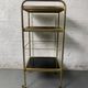 Small rolling trolley in brass and black plastic
