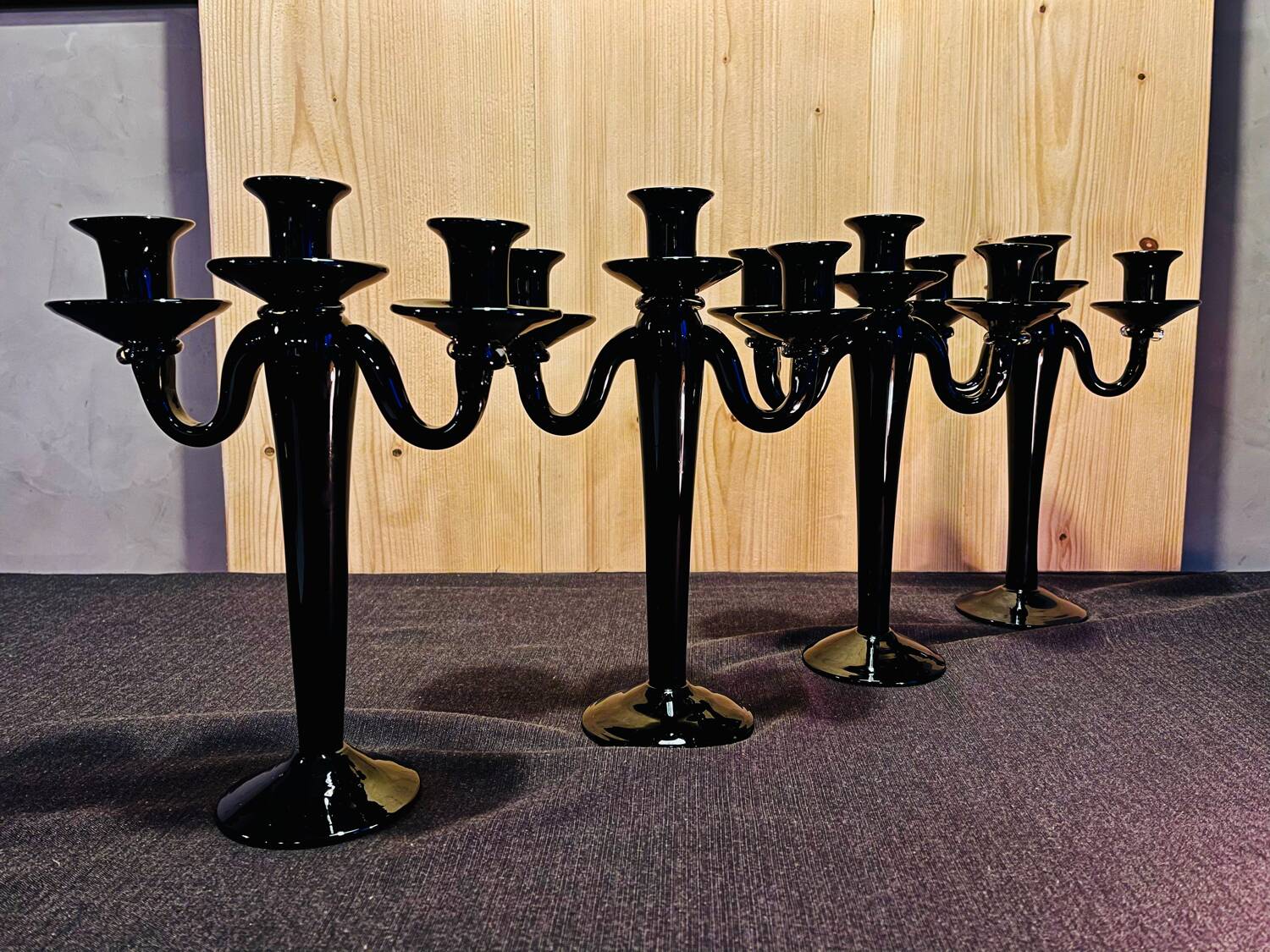 Set of four black glass candle holders.