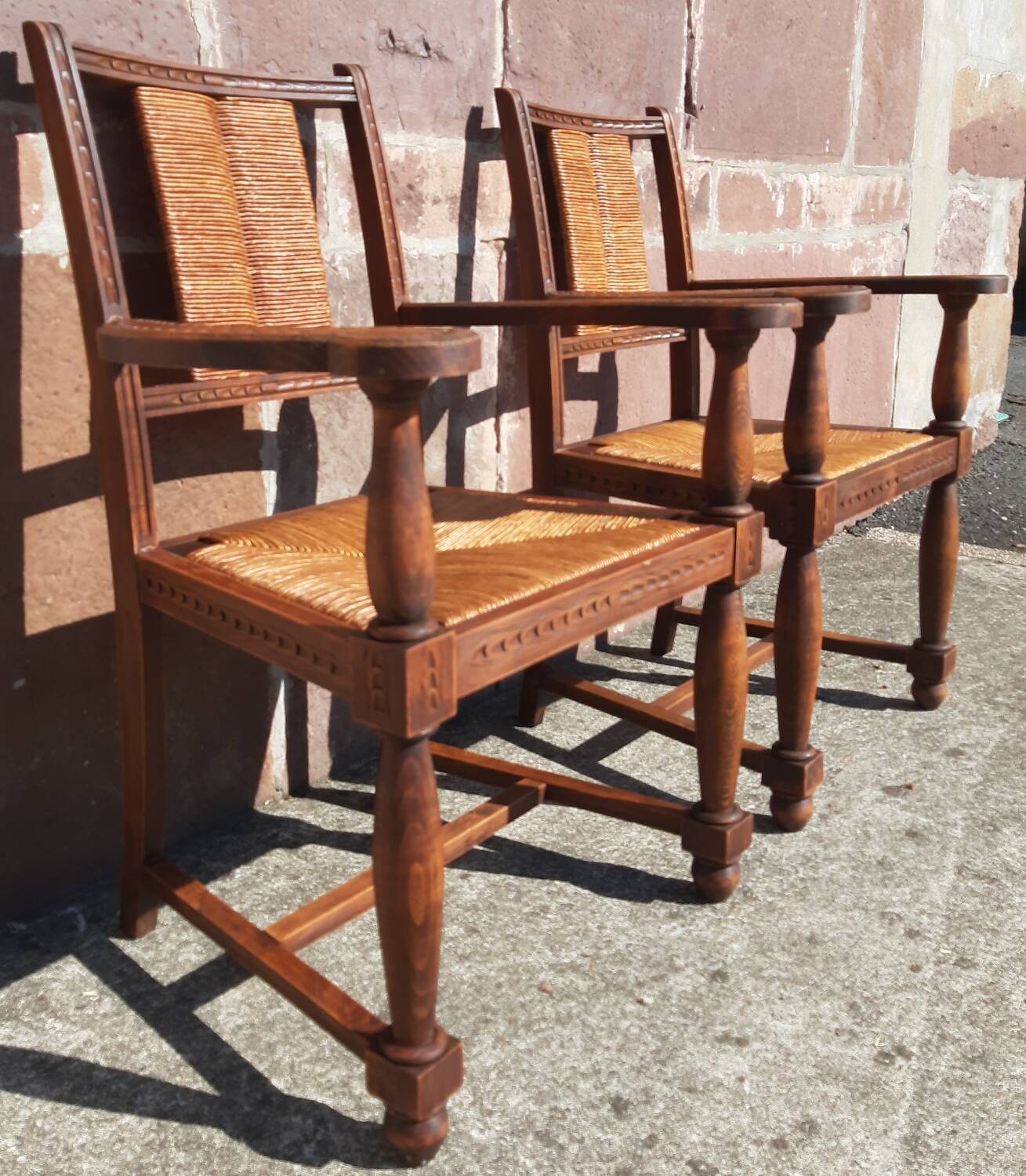 Pair of oak armchairs with straw seats and backs.