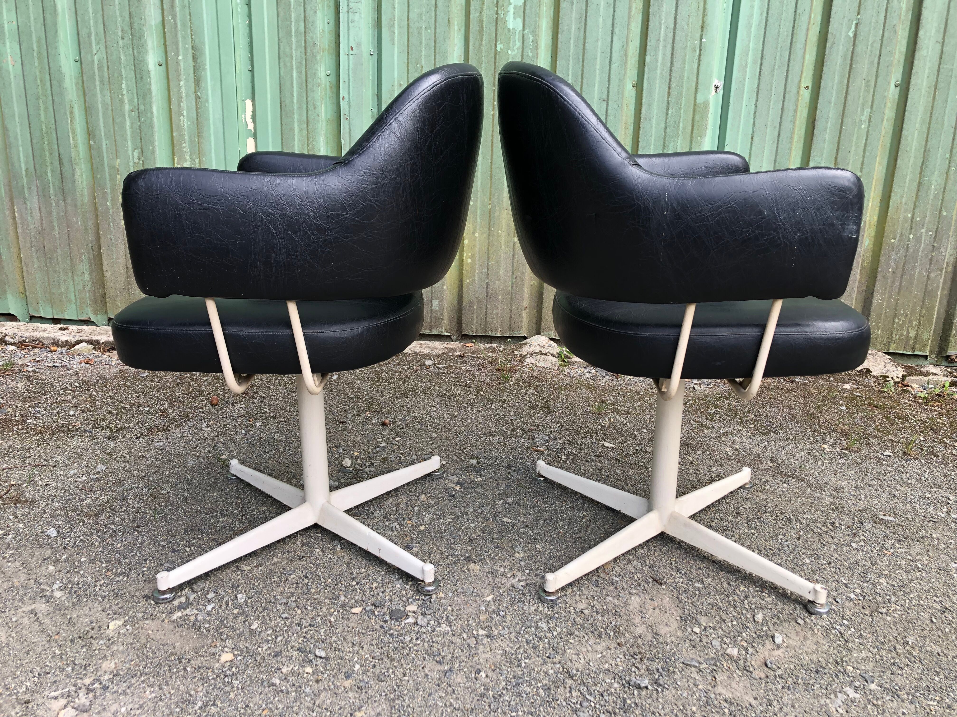 Pair of vintage armchairs in black skai with metal legs.
