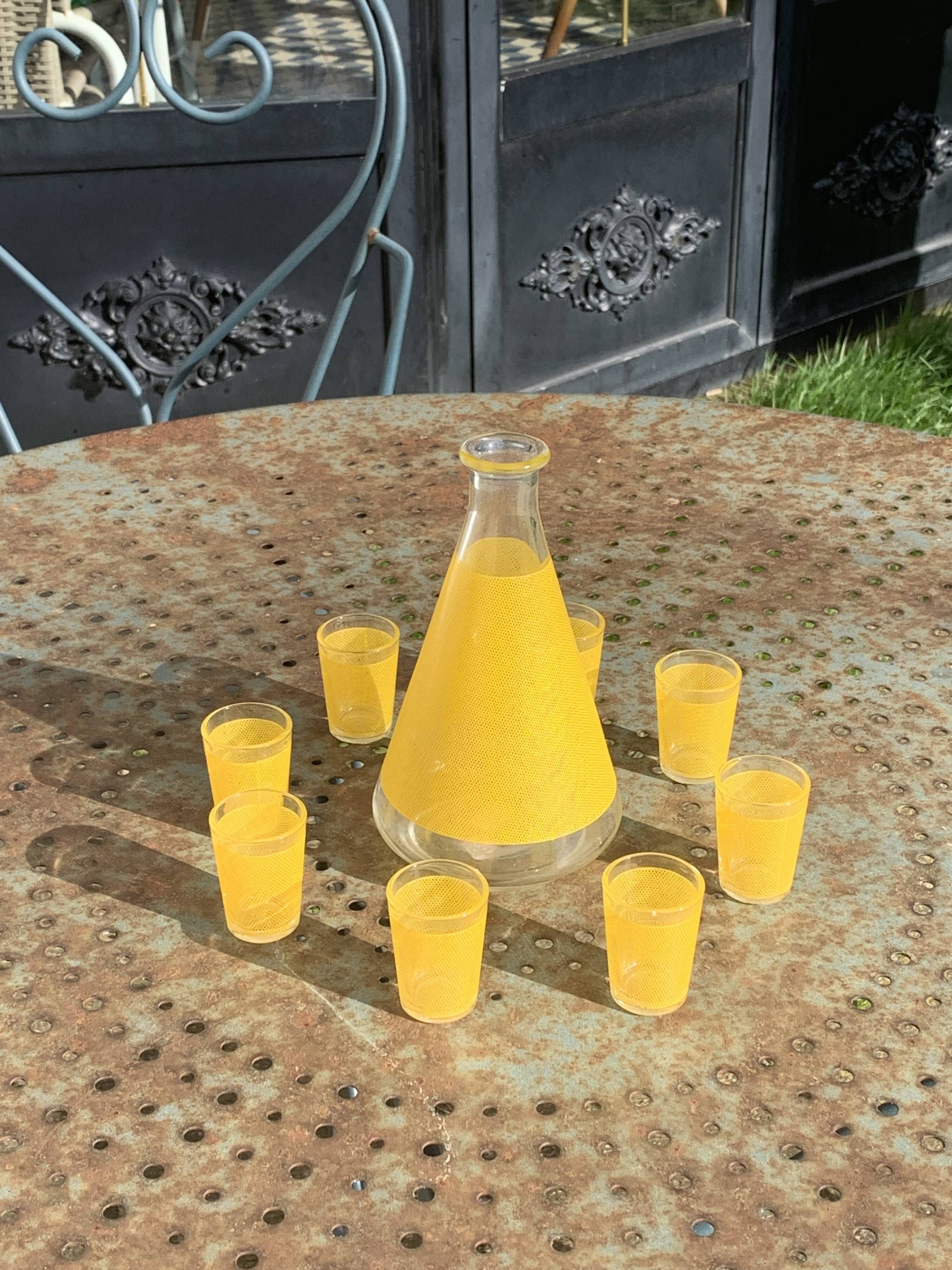 Liqueur service composed of a glass carafe and 8 small yellow screen-printed glasses