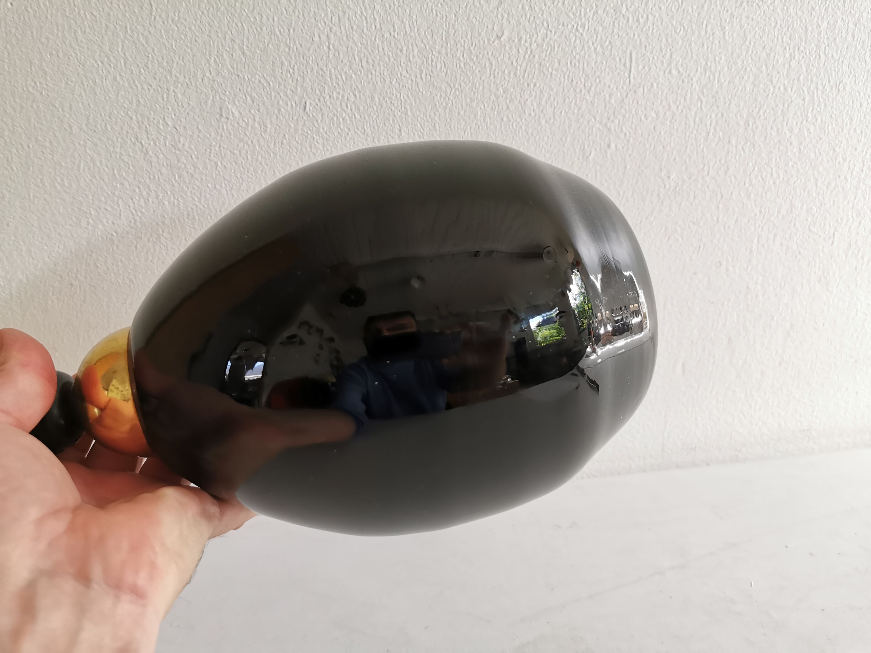 Table lamp, made of handmade coal-black glass, with brass coloured top.