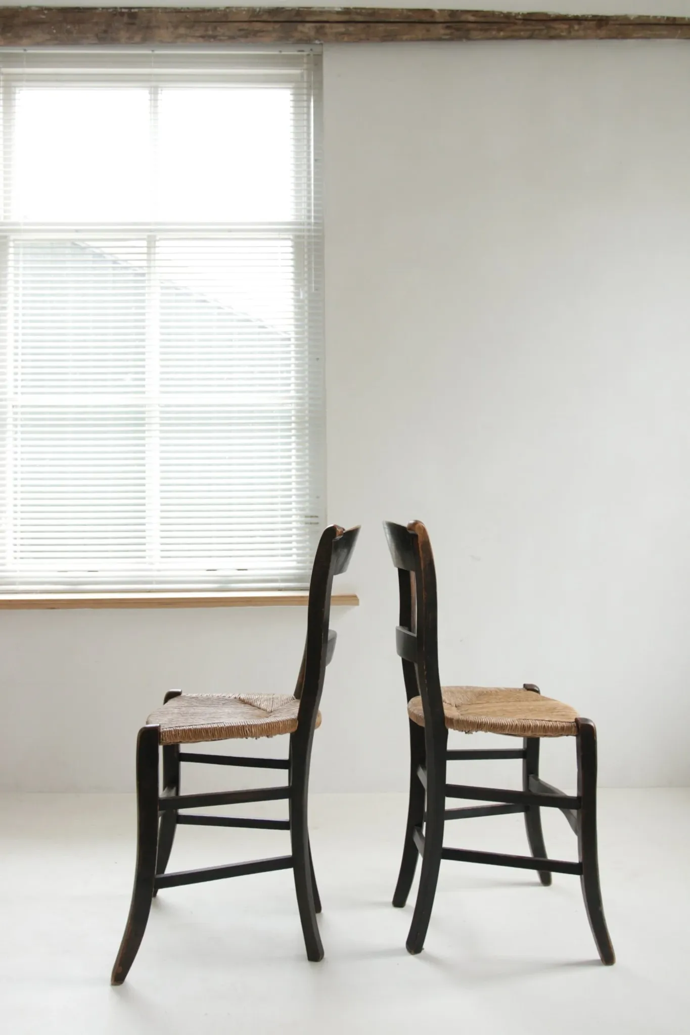 Pair of antique Northern French black-stained chairs with rush seats