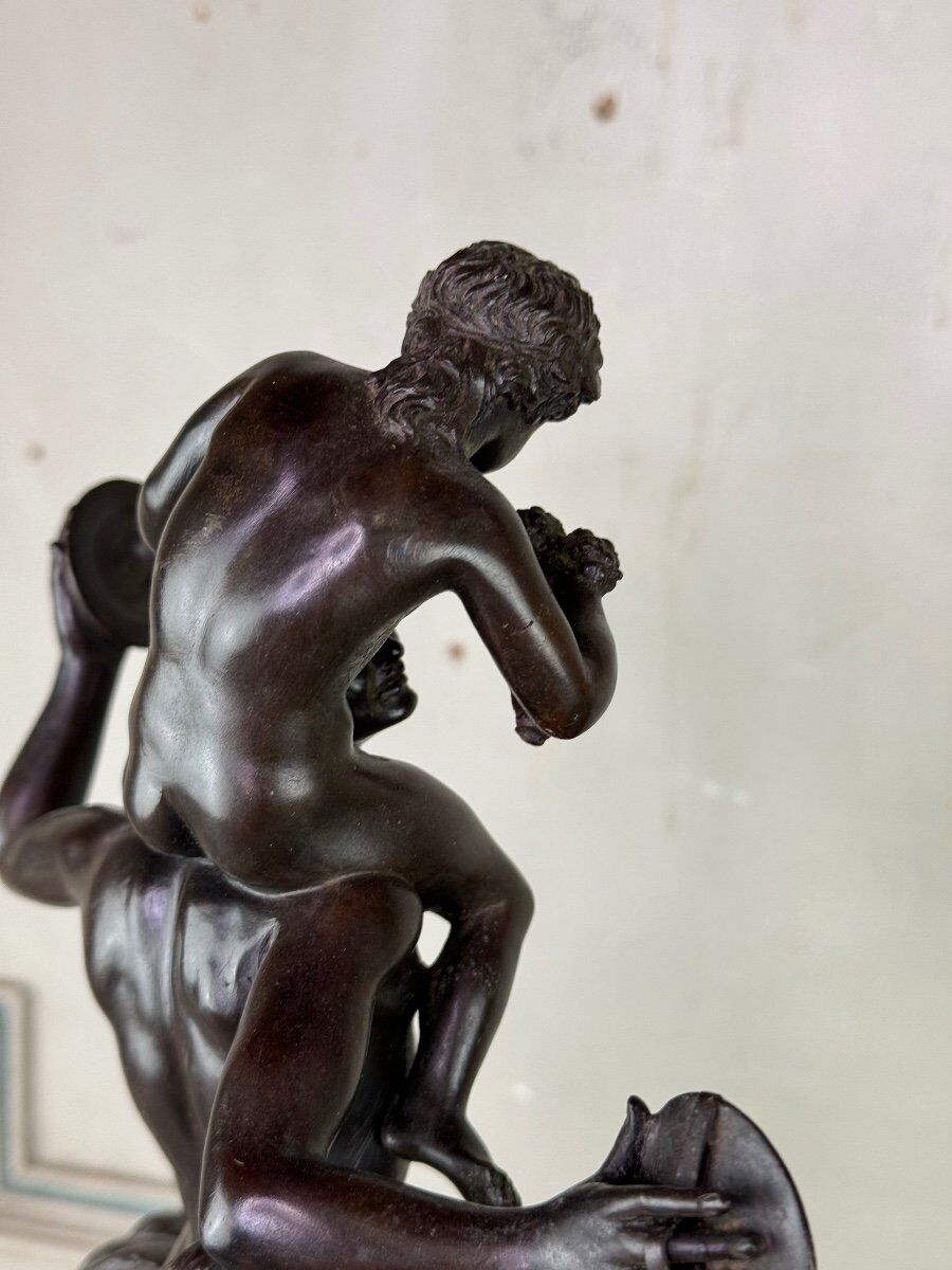 Dionysus on the shoulders of a satyr, bronze after the antique on a yellow Siena base.
