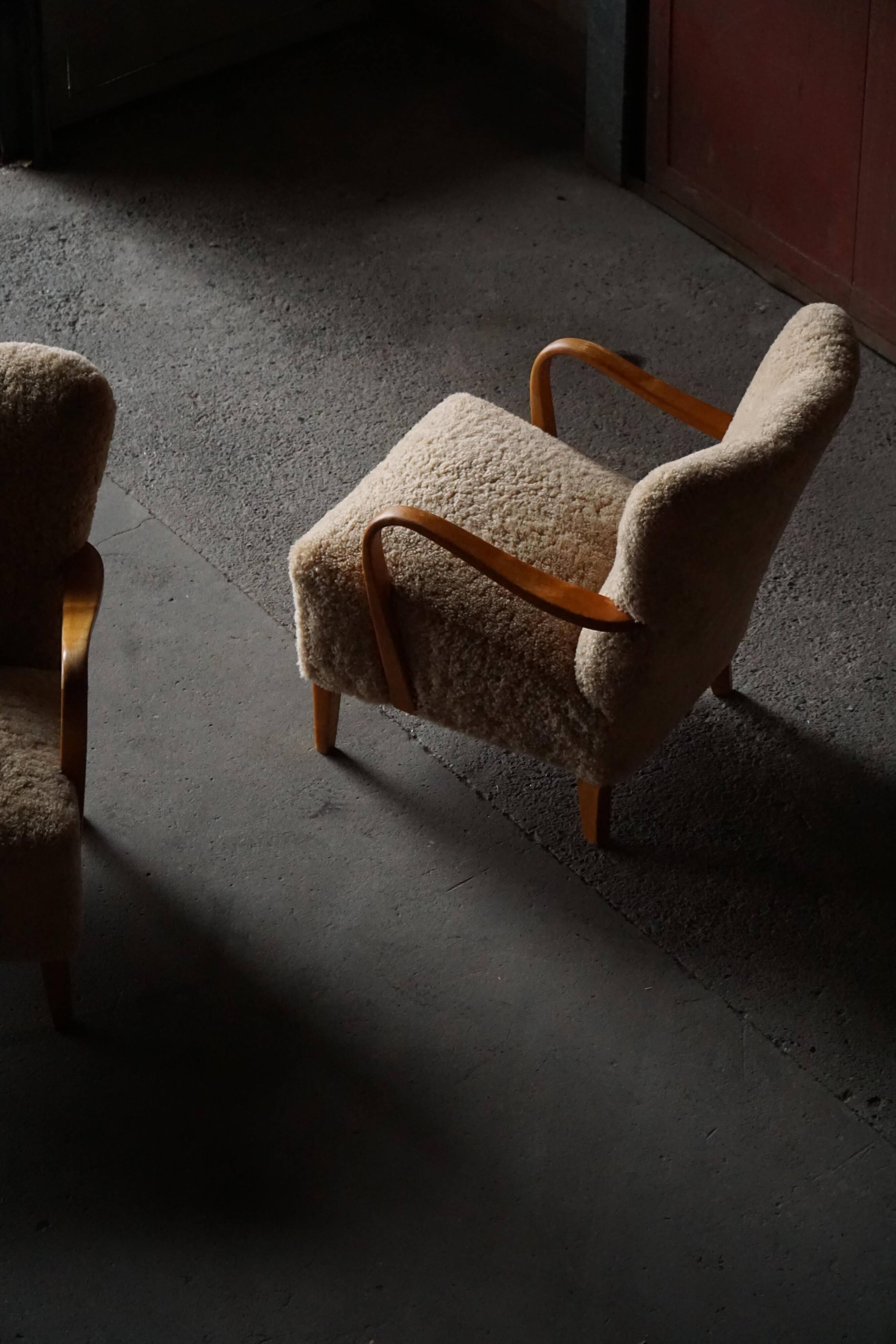 Pair of Mid Century Modern Swedish lounge chairs in birch and lamb's wool, 1960s.