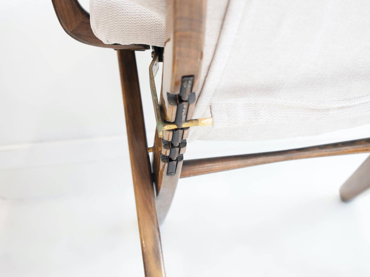 Pair of varnished wooden reclining armchairs, upholstered in lightweight fabric.