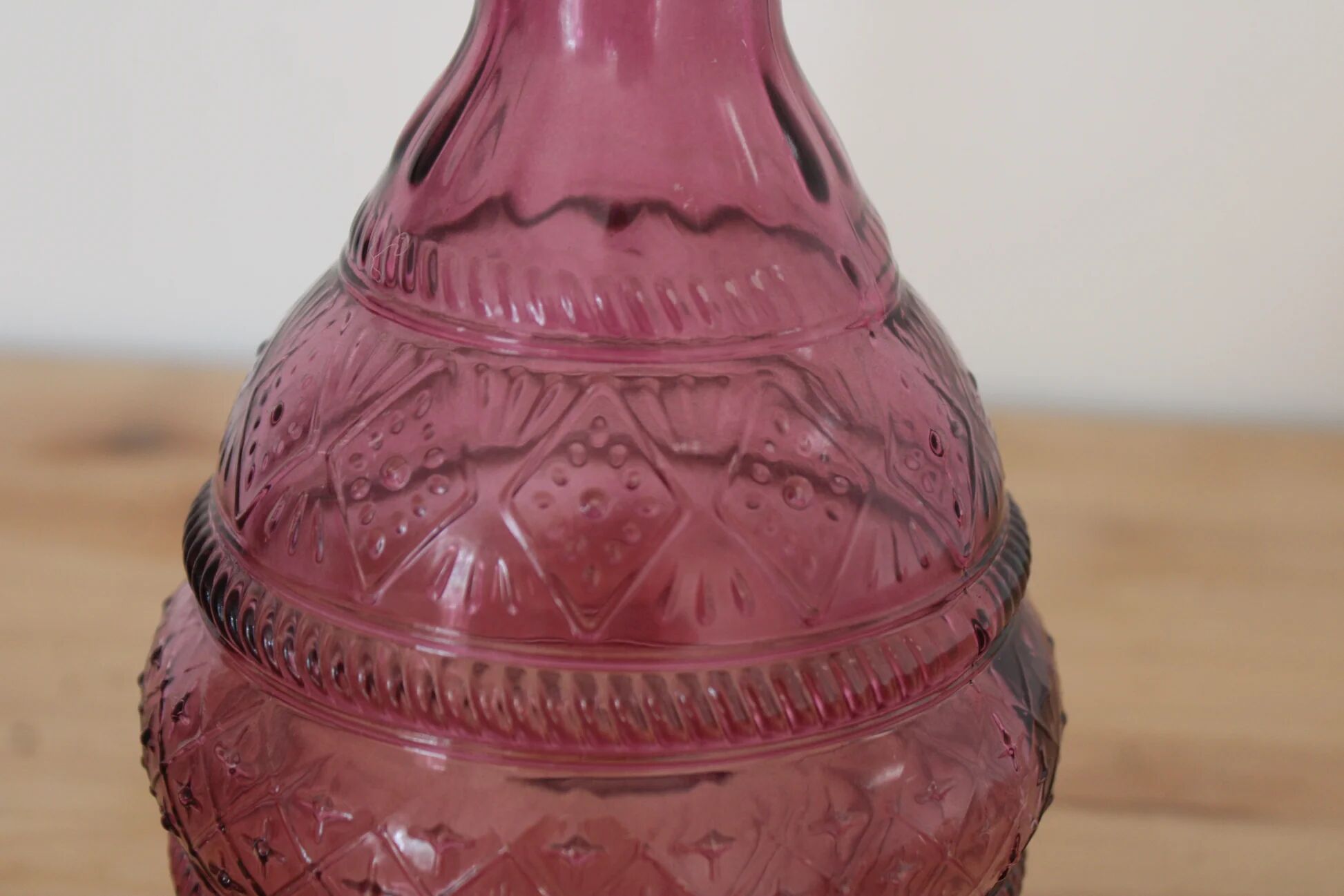 Vintage pink pressed glass carafe – retro decorative bottle with wooden stopper.