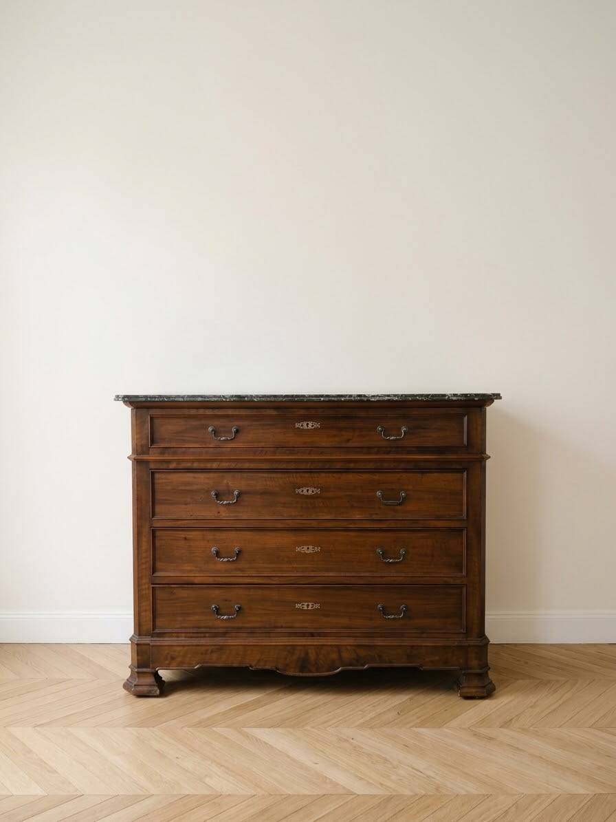 Antique wooden chest of drawers with a marble top.